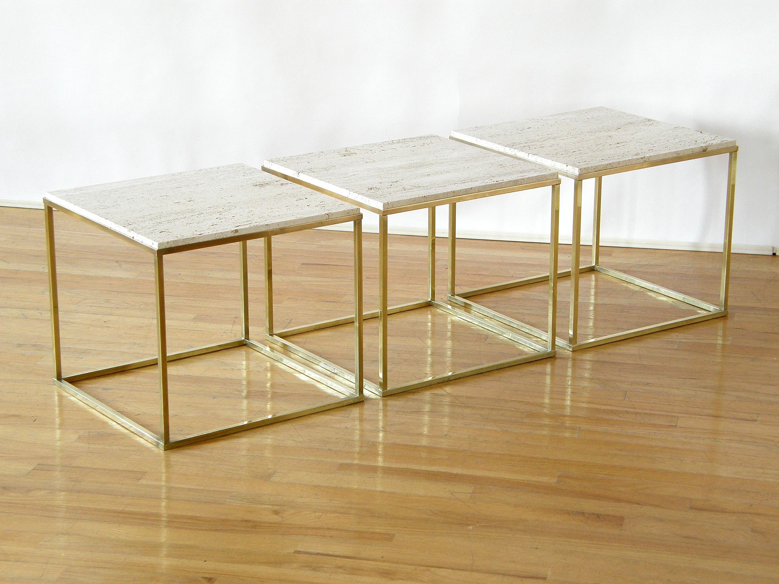 This circa 1950s or 1960s set of three cube tables have open frame brass bases and partially filled travertine tops. They can be used together as a coffee or cocktail table, separately as side tables or chair side drink stands, or as platforms for