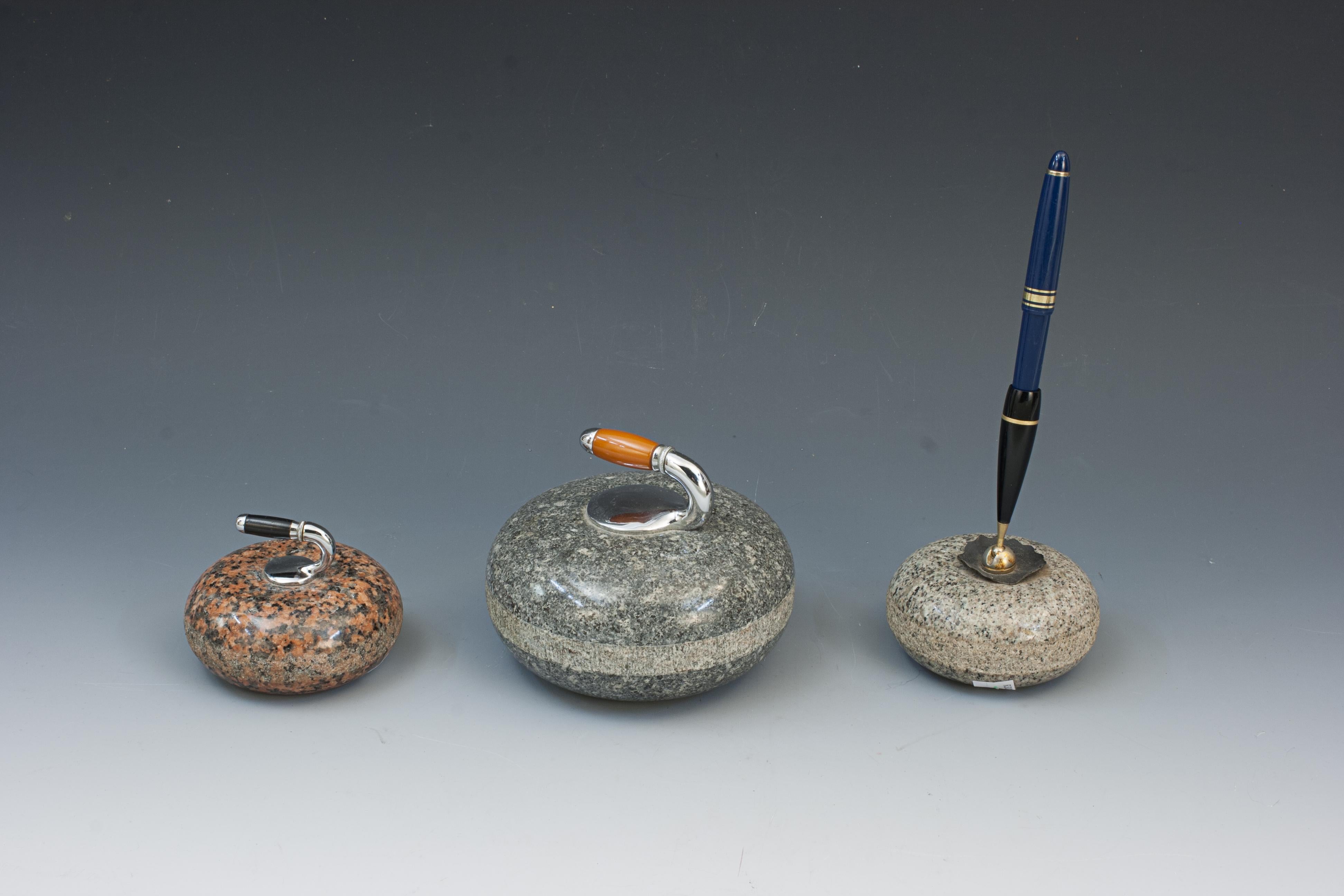 Three Piece Curling Desk Set.
A nice collection of three miniature desk top granite curling stones. Two are paperweights complete with handles and the third is a pen holder. A great little set for the curling enthusiast.

Size shown is for the