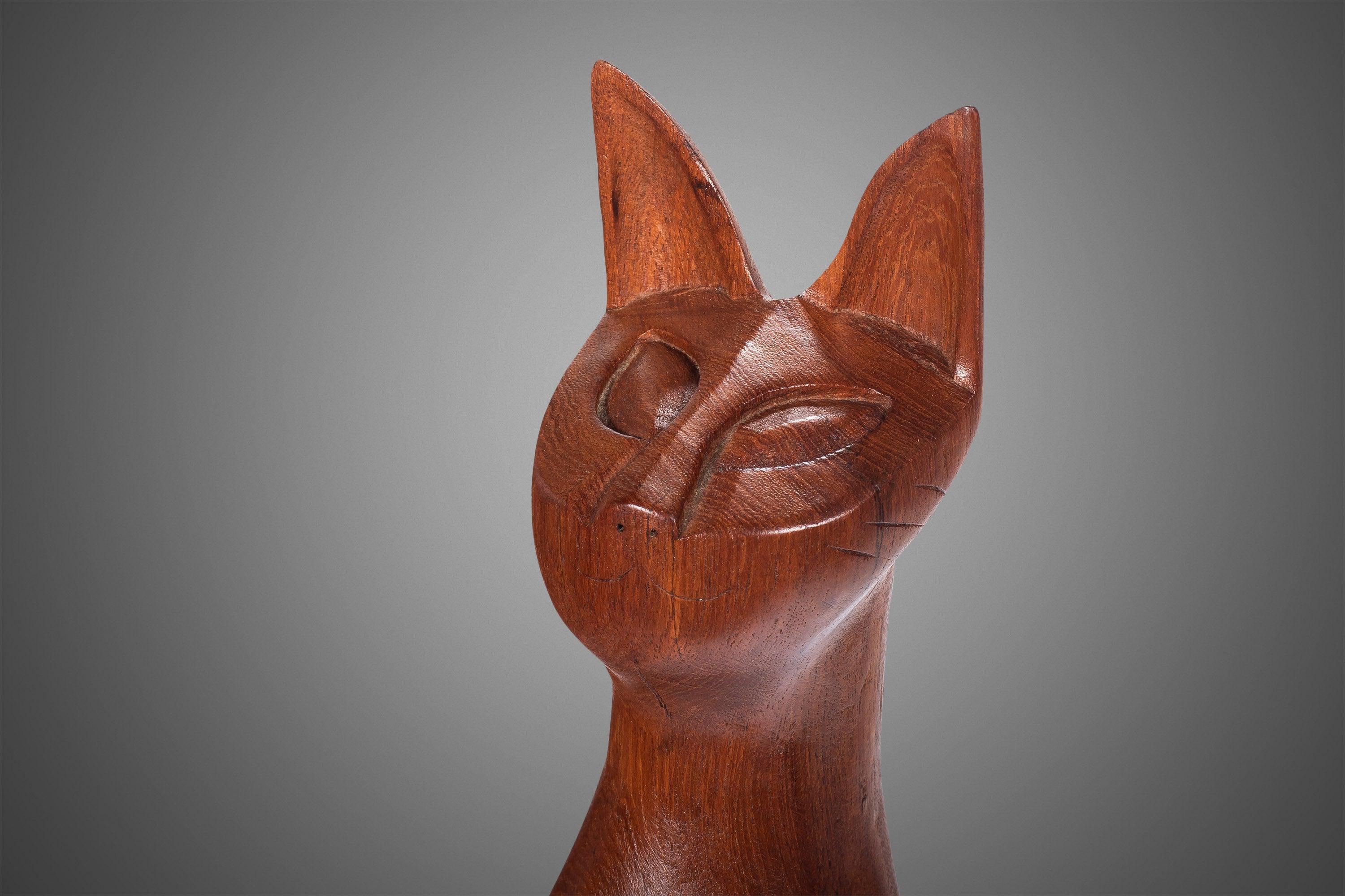 Gorgeous and quirky set of sculpted figurines. These stylized cats have the era appropriate influence, and created with intent to last ages. Made of solid teak in wonderful condition. Smallest Cat: 12 in tall by 2.75 in wide by 2.5 in deep. Medium
