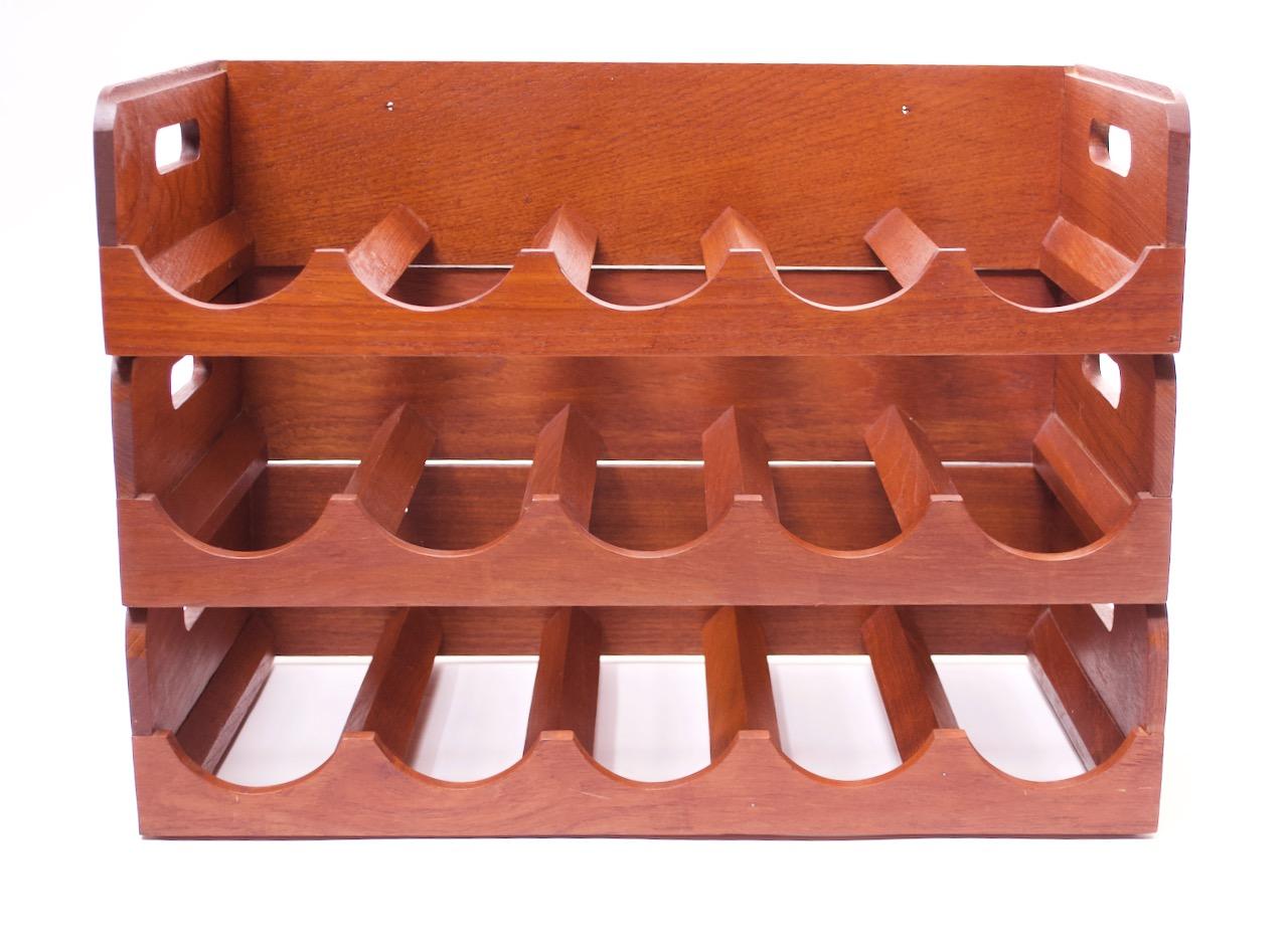Set of three teak wine racks by Kalmar that can be used separately or stacked together. Handle feature allows for easy transport of each unit. Each section holds five bottles (15 in total) and includes two small holes in the back panel for wall