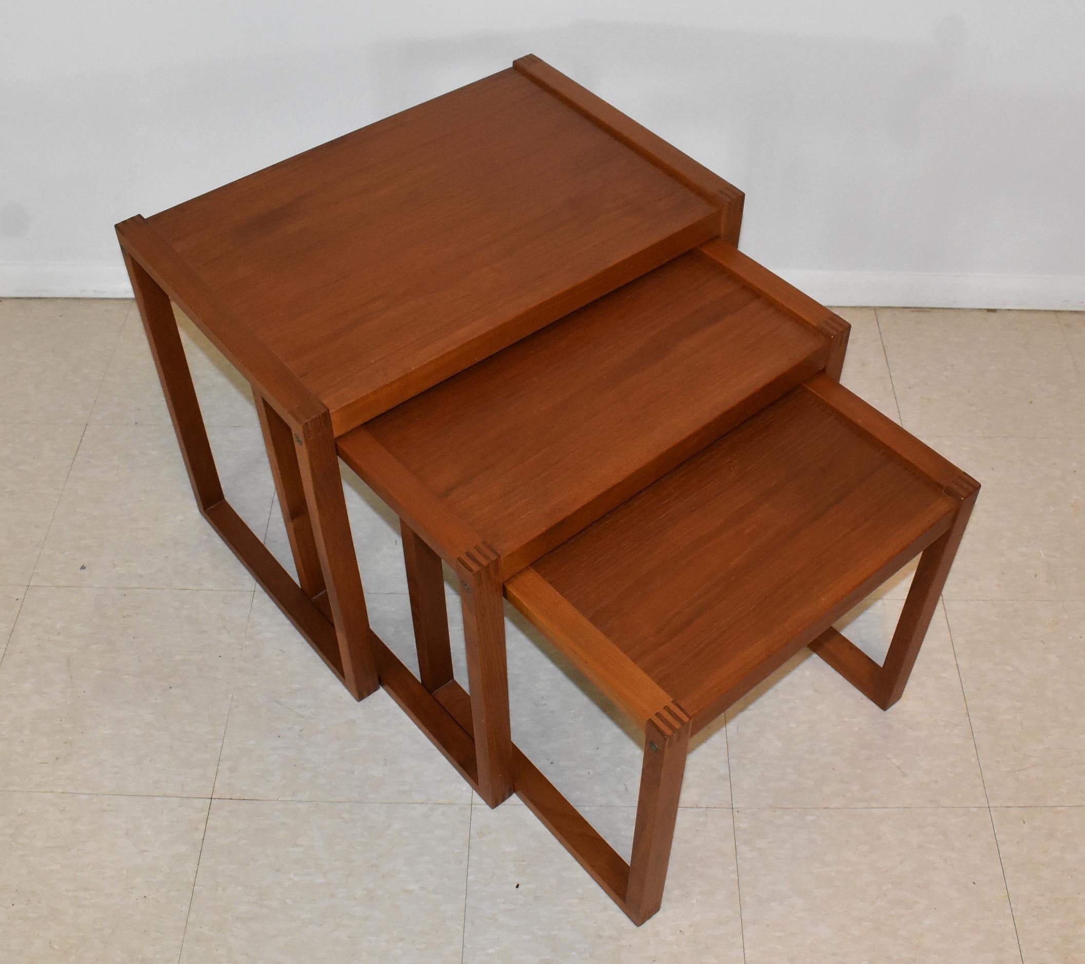 Set of three Danish modern teak nesting tables by Vi-Ma Mobler. Finger joint construction. All tables stamped Denmark. One table has small dark water ring. All in very good condition. Tallest table measures 16