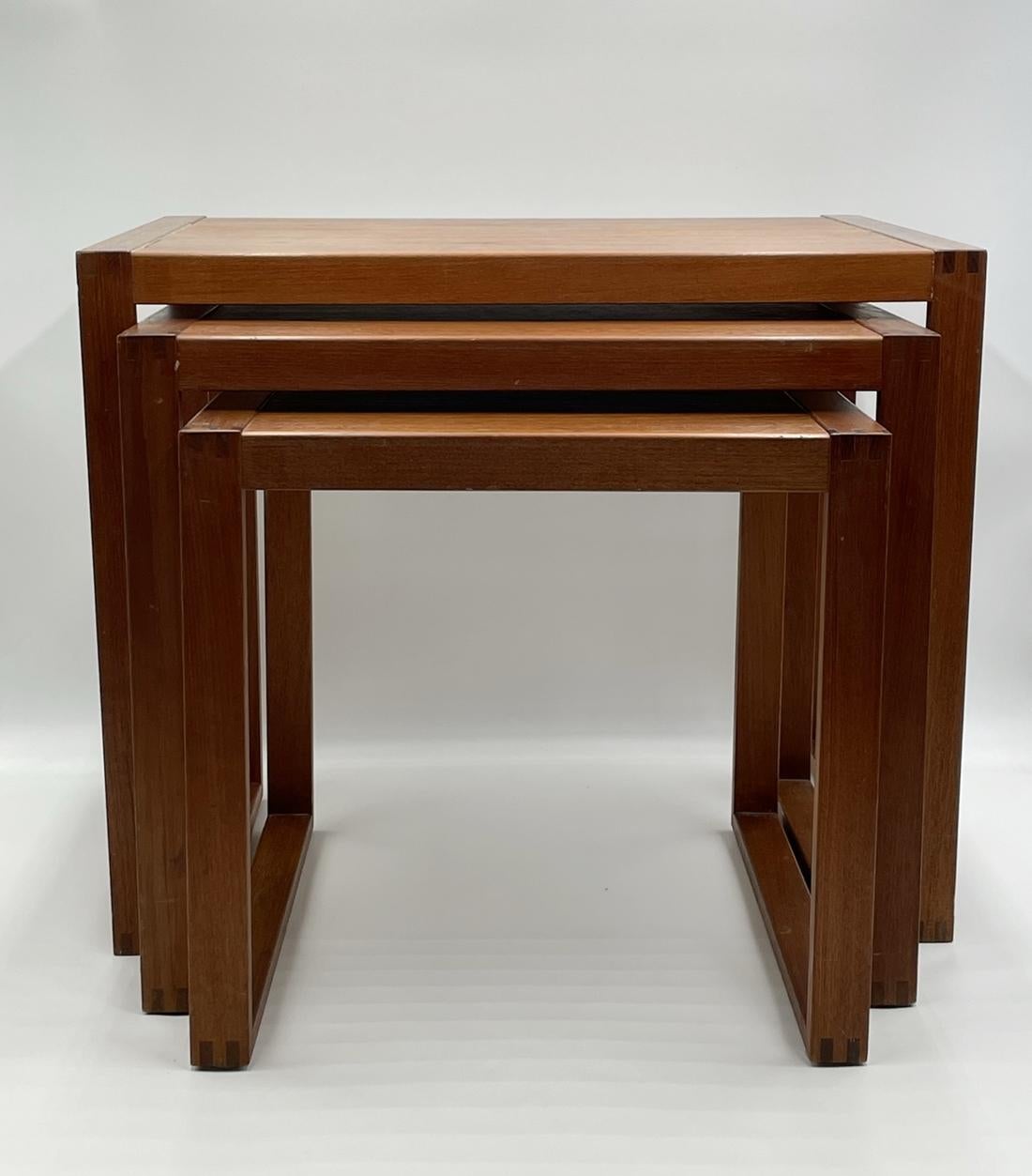 Introducing the Set of Three Danish Modern Teak Nesting Tables by Vi-Ma Mobler - the perfect addition to your living room or office space. Crafted with high-quality teak wood, these beautifully designed nesting tables offer both style and