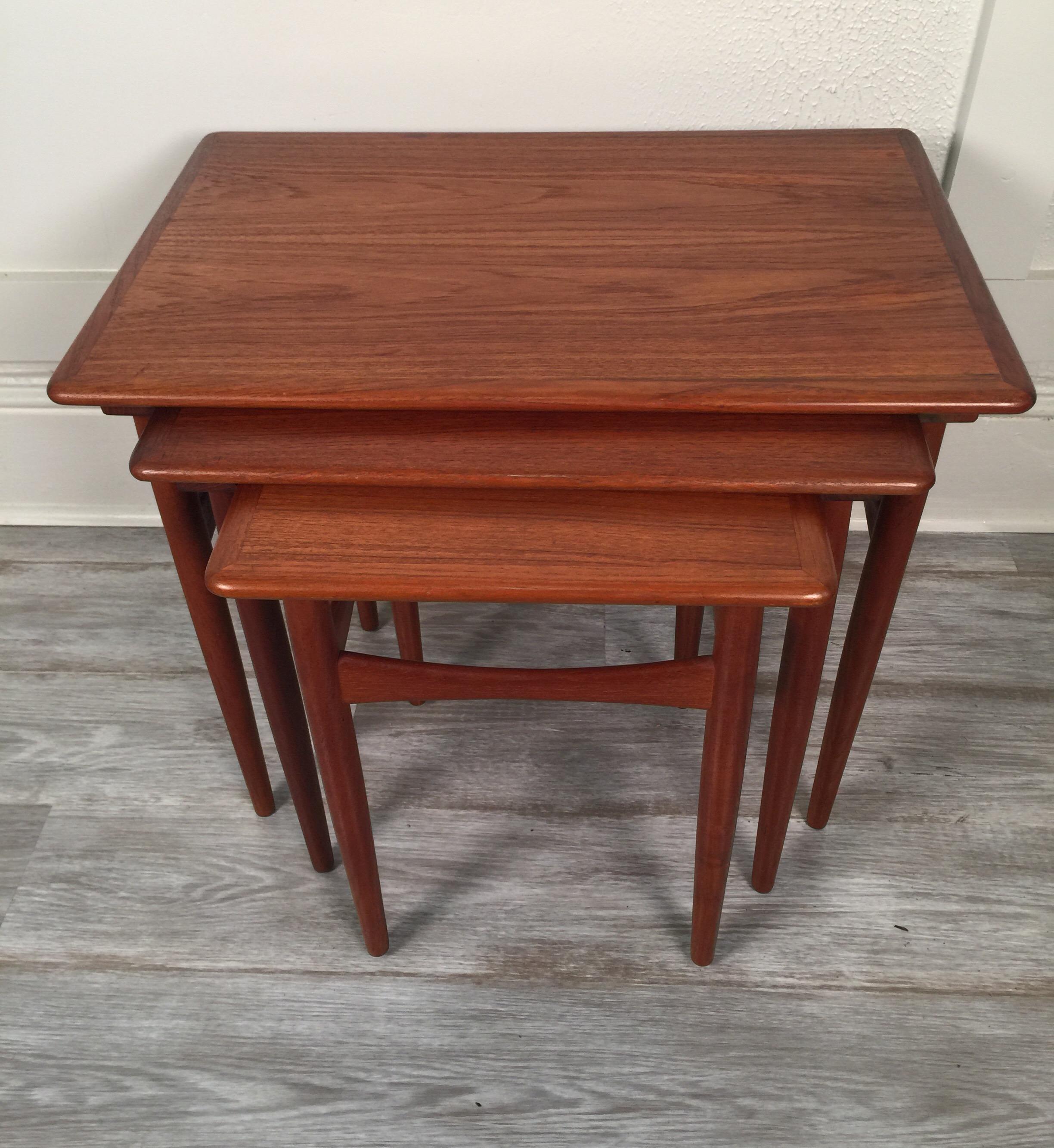 Beautiful and well-made set of three Danish teak nesting tables. This set features banded edges and a nice warm patina.