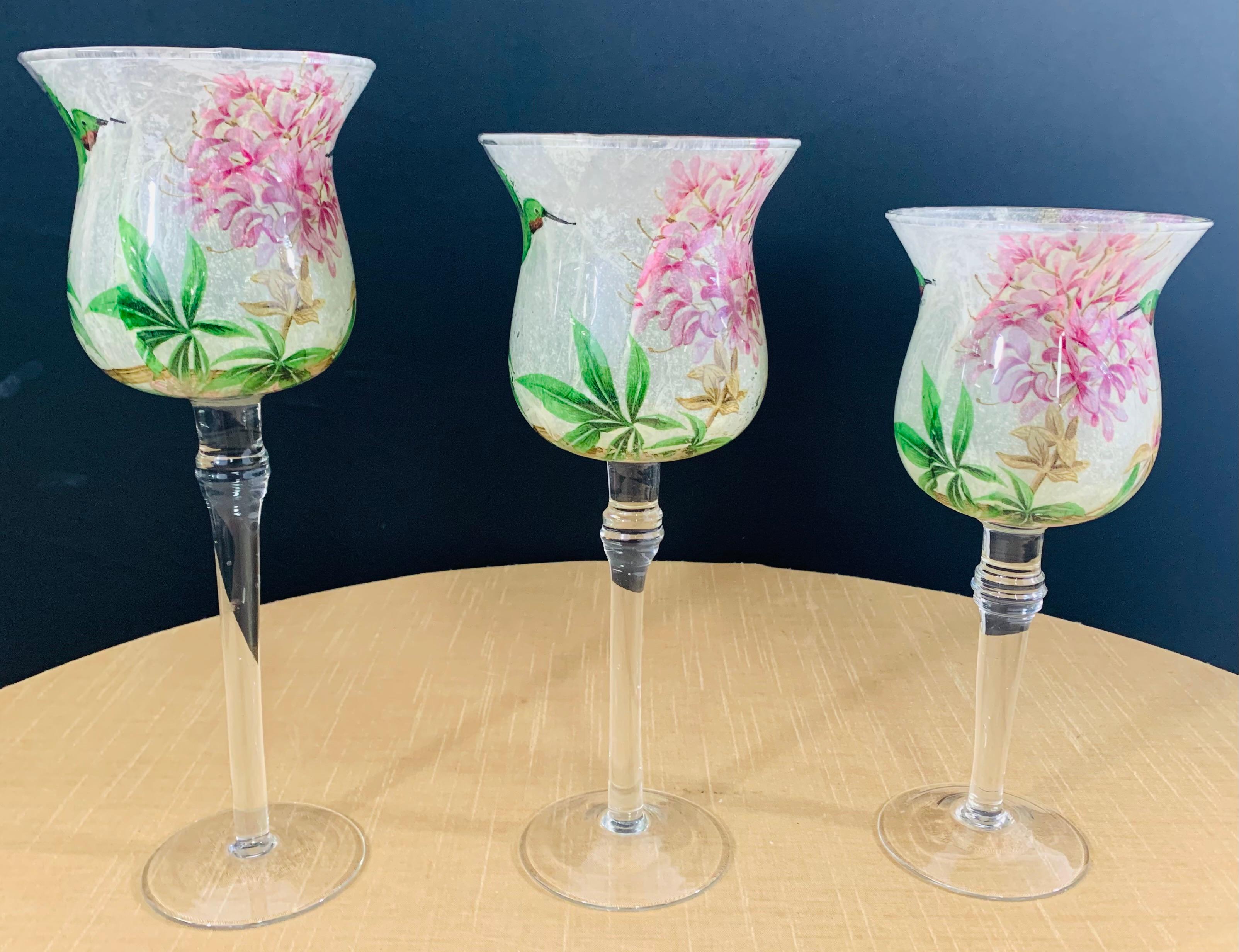 A stylish and decorative set of three glasses. Each glass has been permanently sand blast etched with the Hummingbird and flourish designs in a very spring like color tones including green, pink and light purple.

Dimensions: 
Large: 12
