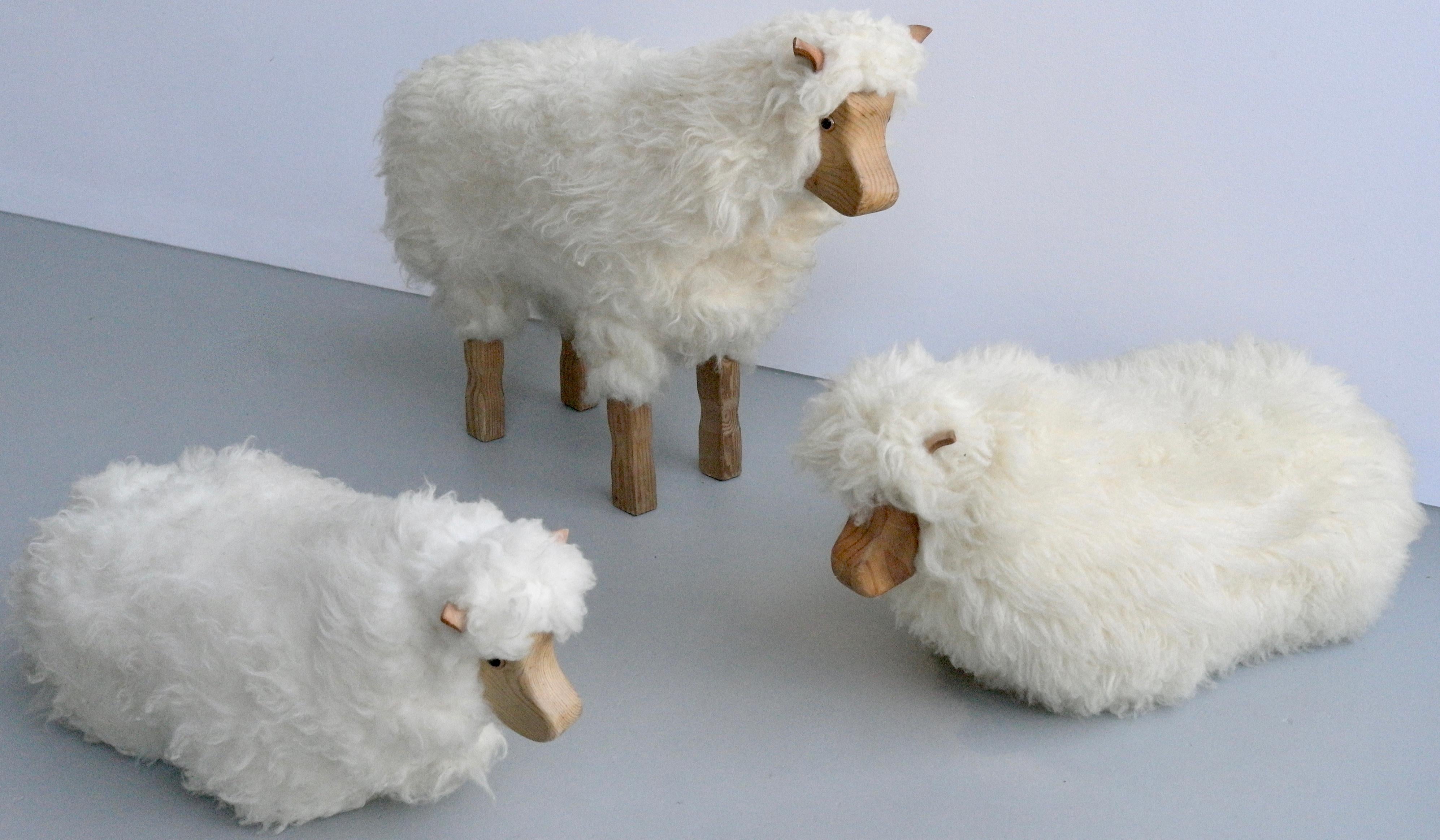 Set of three decorative sheeps in pine wool and leather, Germany 1970s. One standing and two sitting , one large and one smaler. These sheeps are made of solid pine and is covered with real sheep wool, there ears are made of natural sling leather.