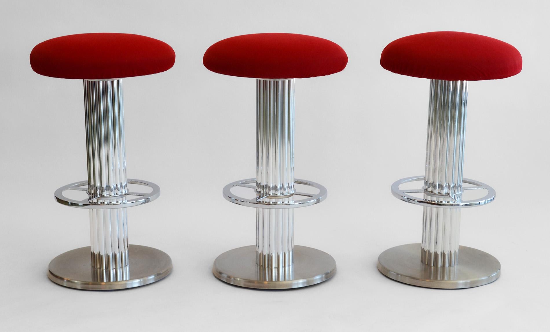 Set of Three Design For Leisure Modern Steel Bar or Counter Swivel Stools 1980s
Bar stools in polished and brushed nickel over steel frames with newer red upholstery on cushion seat. Stools are very heavy. Post Modern or Art Deco polished aluminum