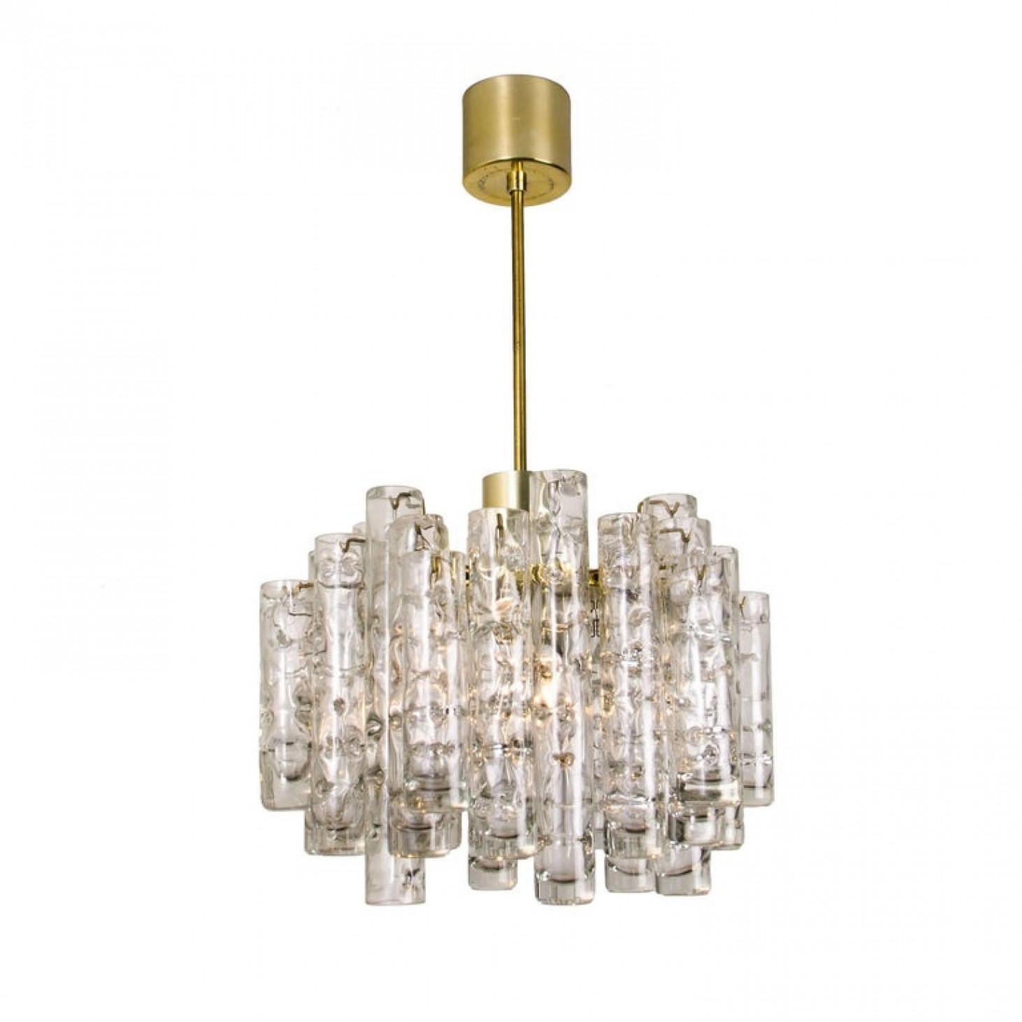 Te ofrecemos un sorprendente conjunto de luminarias Doria. Las luminarias de tres luces tienen un marco con detalles de latón y grandes tubos de cristal. El cristal tiene un bonito dibujo, lo que proporciona un bonito efecto de luz difusa y un