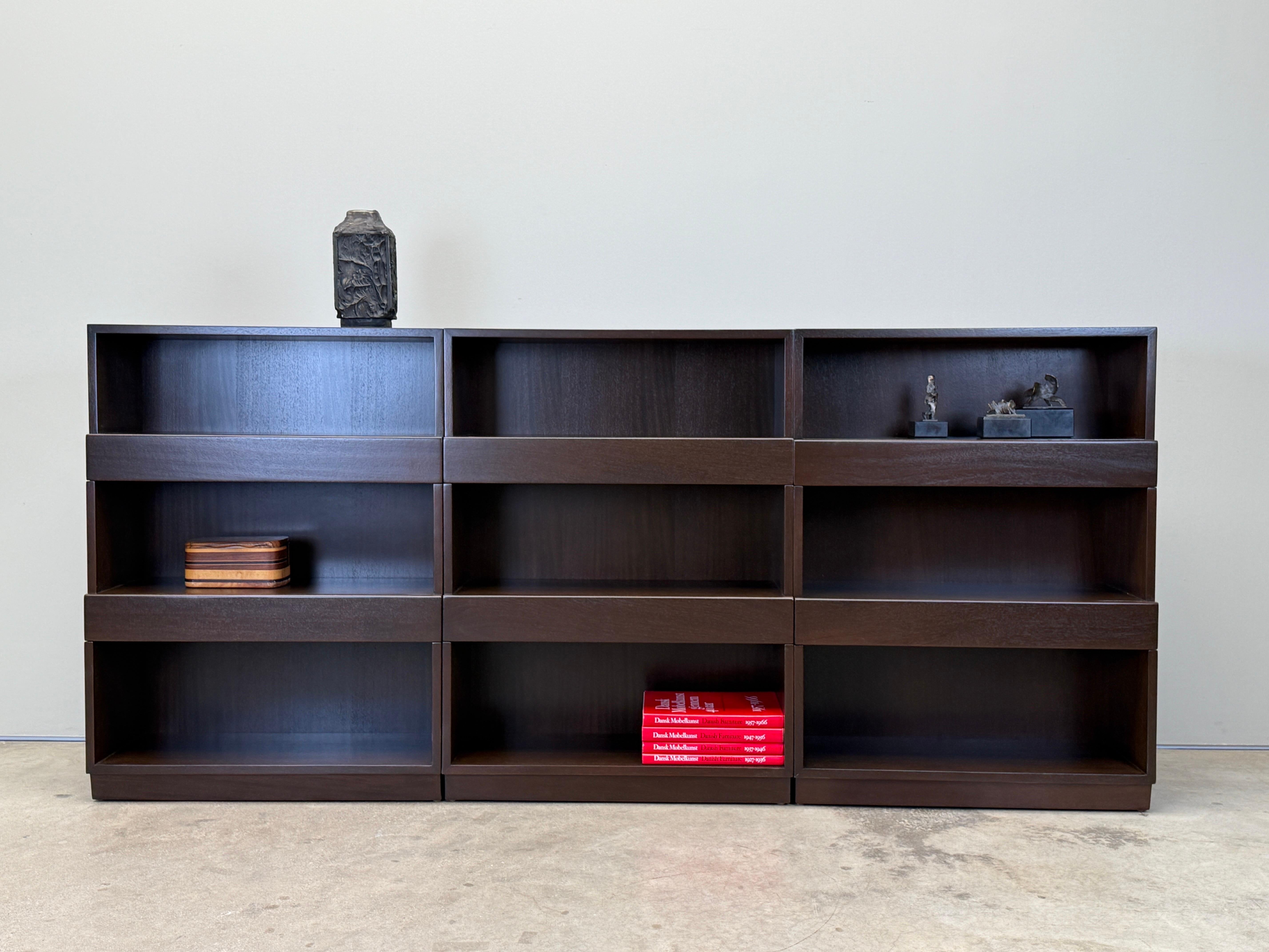 A set of three mahogany stepped bookcases with built in drawers. Designed by Edward Wormley for Dunbar. Each cabinet measures 30