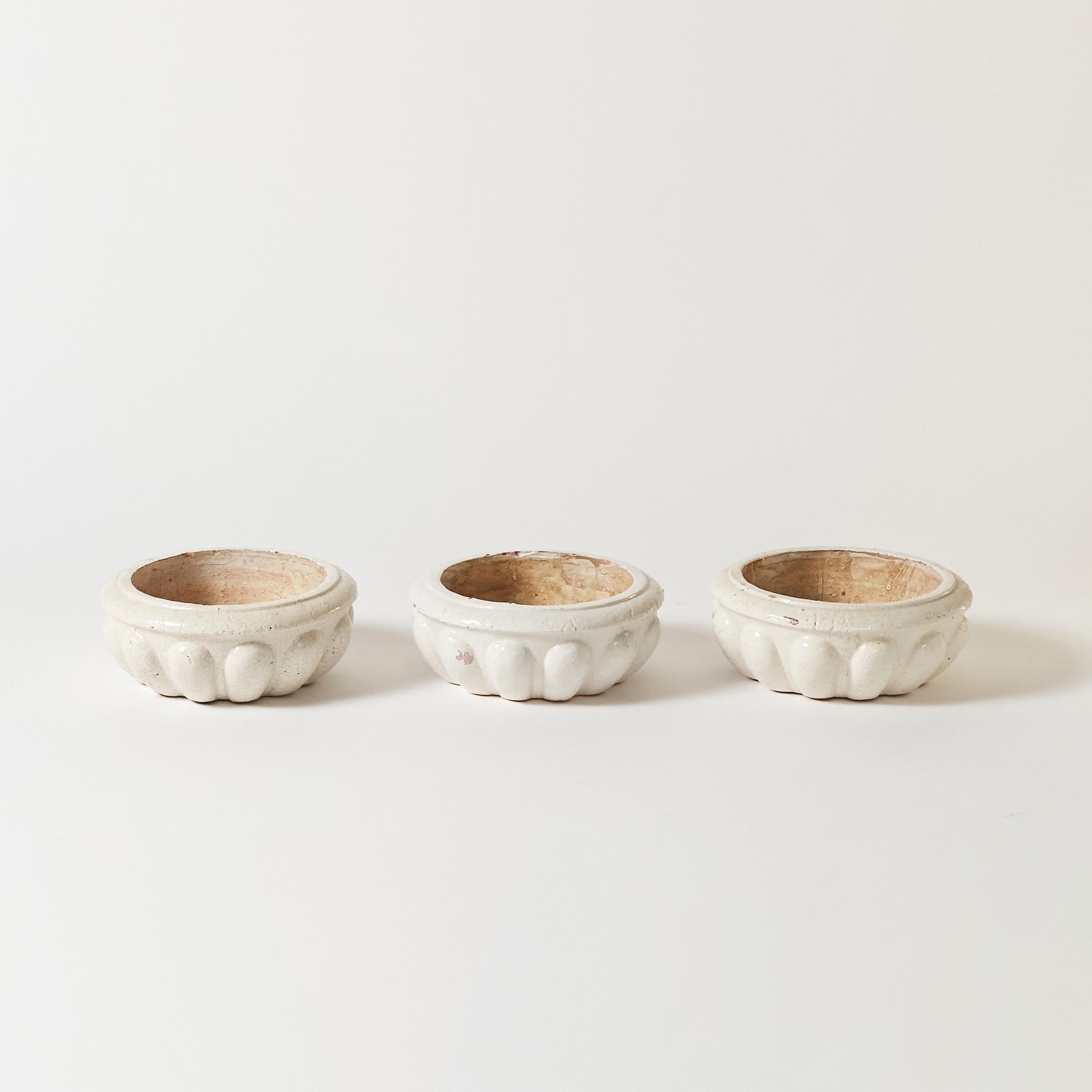 Set of three Dutch terracota low round planters finished in white crackled glaze finish.
PTMD stamped on bottom.