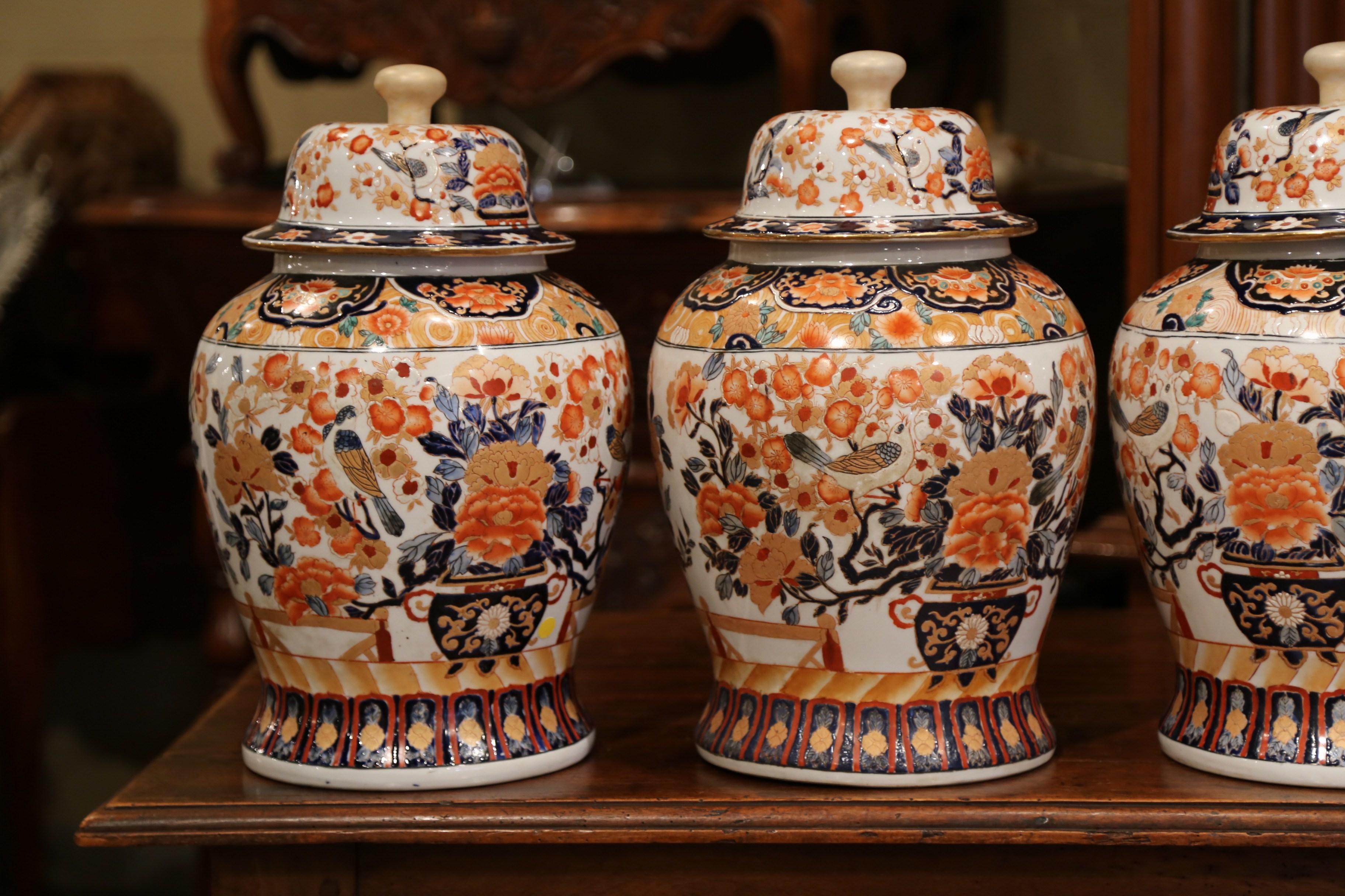 Decorate a console or mantle with this important set of colorful antique porcelain ginger jars. Created in China, circa 1920, each exotic, hand carved vase is decorated with a classic, Asian, floral and bird motif in a blue, white and orange