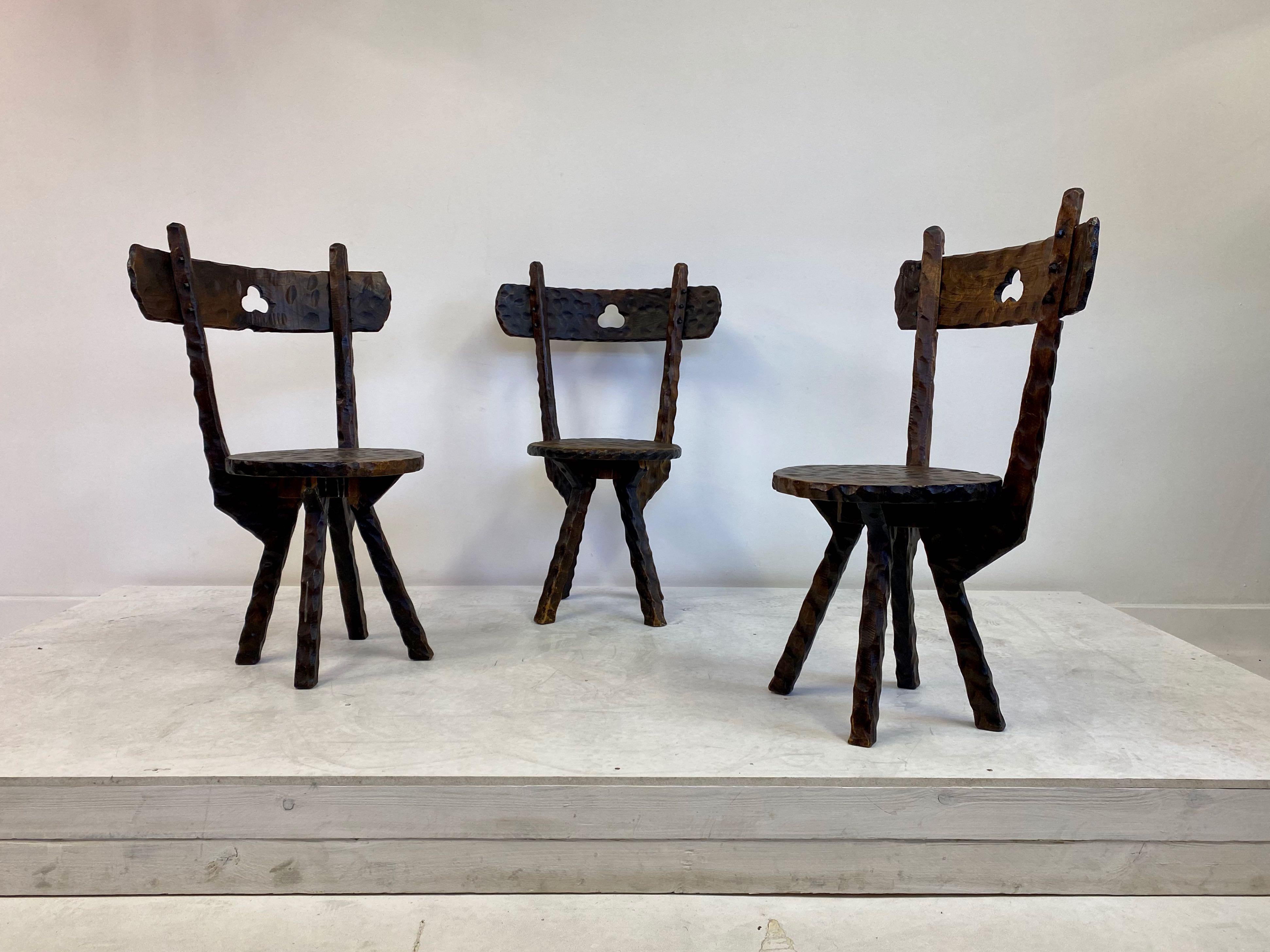 Three adzed wood chairs

cutout heart detail 

Primitive and rustic in style

Early 20th century

Size: Seat height 40cm.