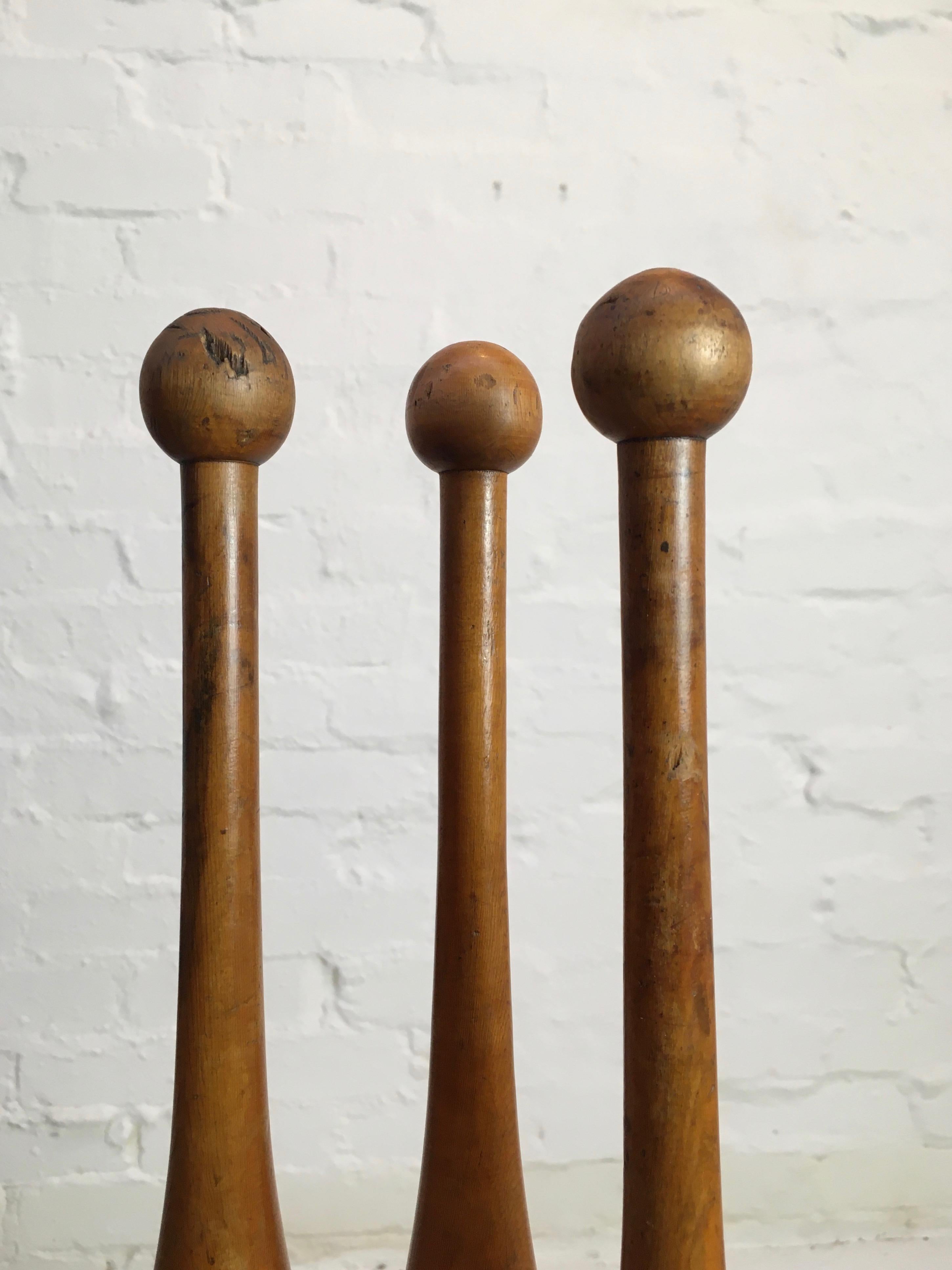 A beautifully colored and patinated set of three antique juggling pins. These are well-used and have acquired a deep character and rich color.

We've cleaned and lightly waxed them as they were coated in bits of desiccated newspaper from storage.