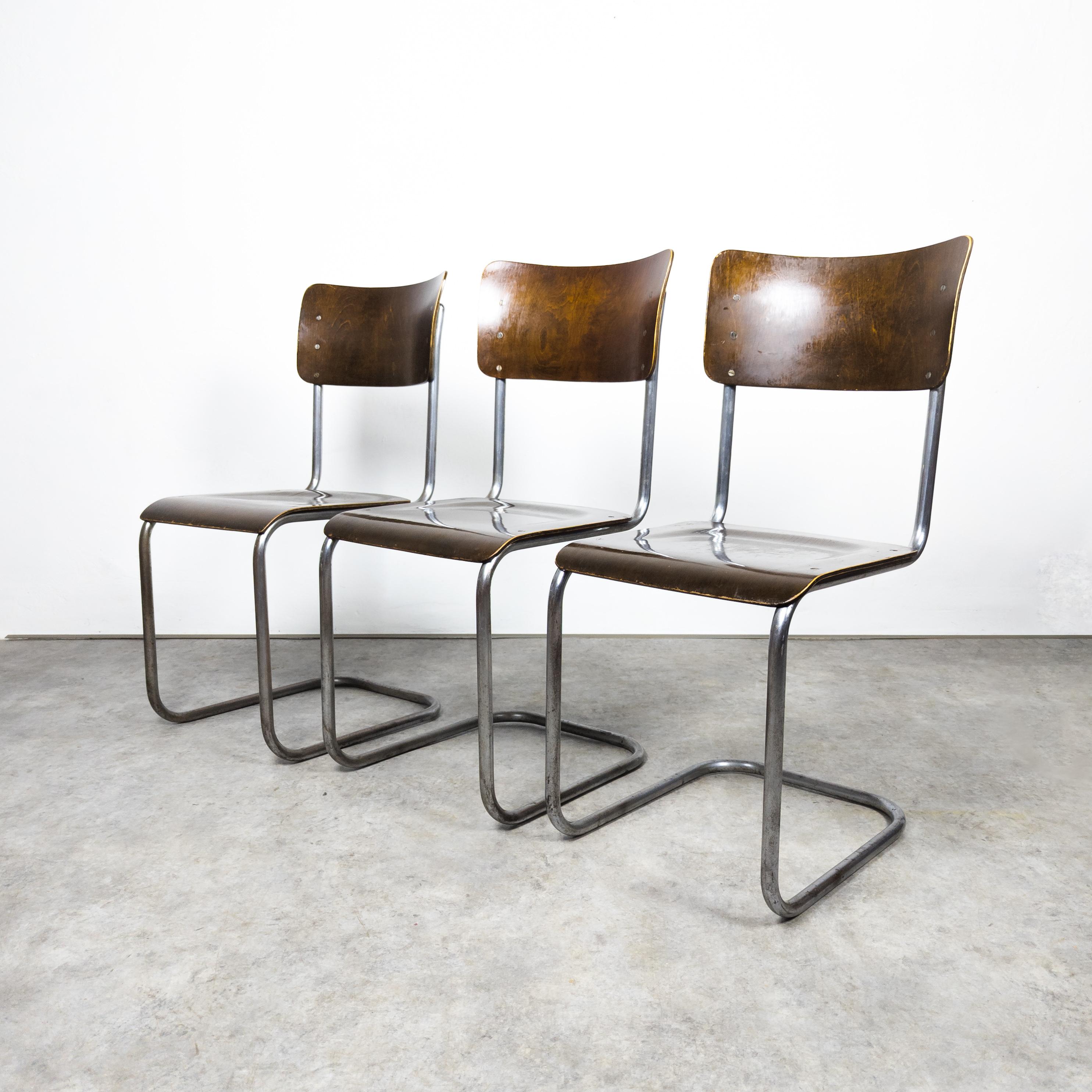 Rare version manufactured by Vichr & co. , former Czechoslovakia in the 1930s. Set of three Bauhaus cantilever chairs with a sturdy tubular steel frame, showcasing vintage charm. The steel elements exhibit distinct signs of aging, while the wooden