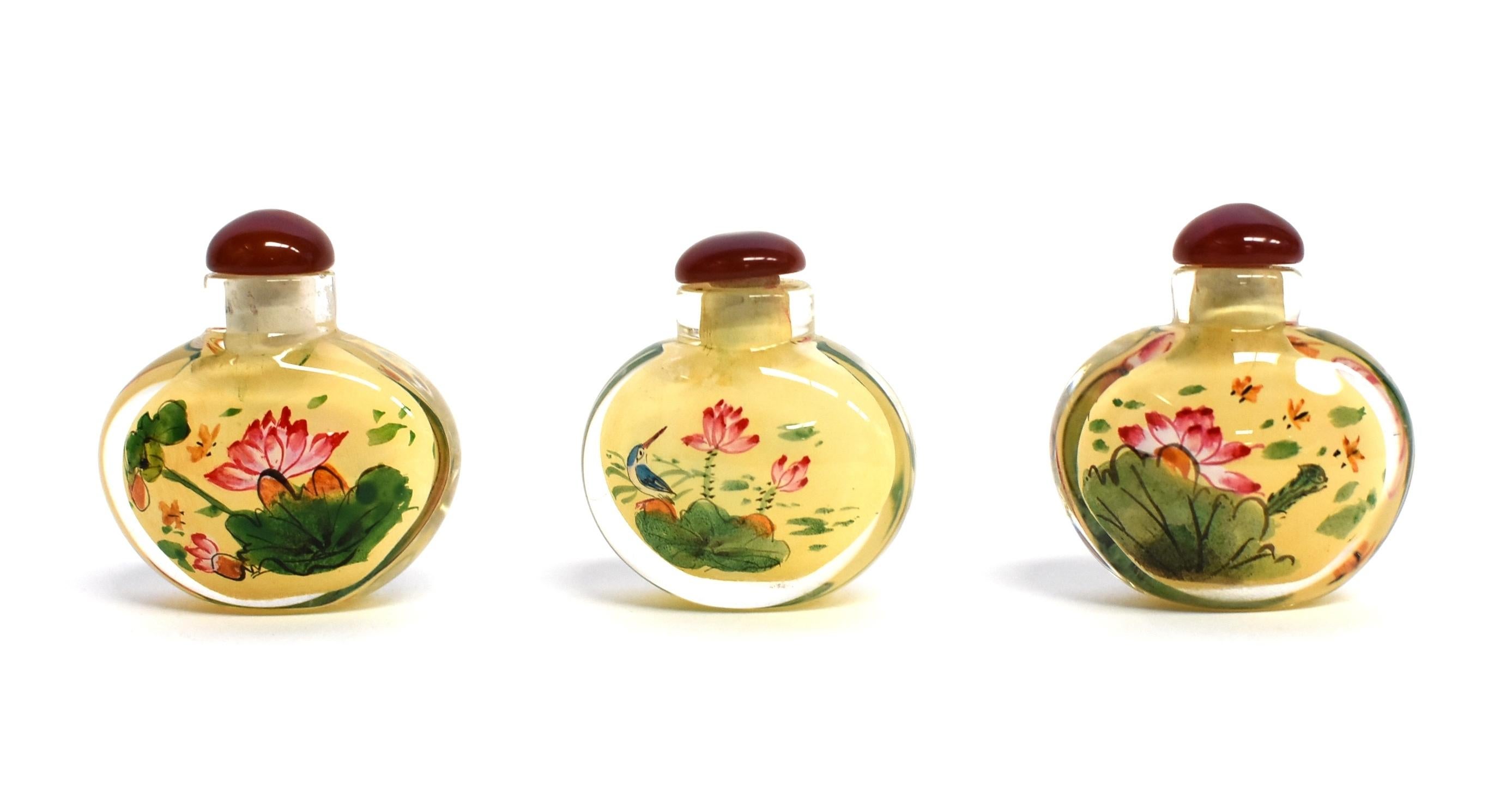 Our snuff bottles are topped with gemstone grade agate lids and 100% hand painted from within. The Chinese art of eglomise uses a very thin bamboo brush with a few strands of hair to apply watercolor on the inside walls of the blank glass bottle