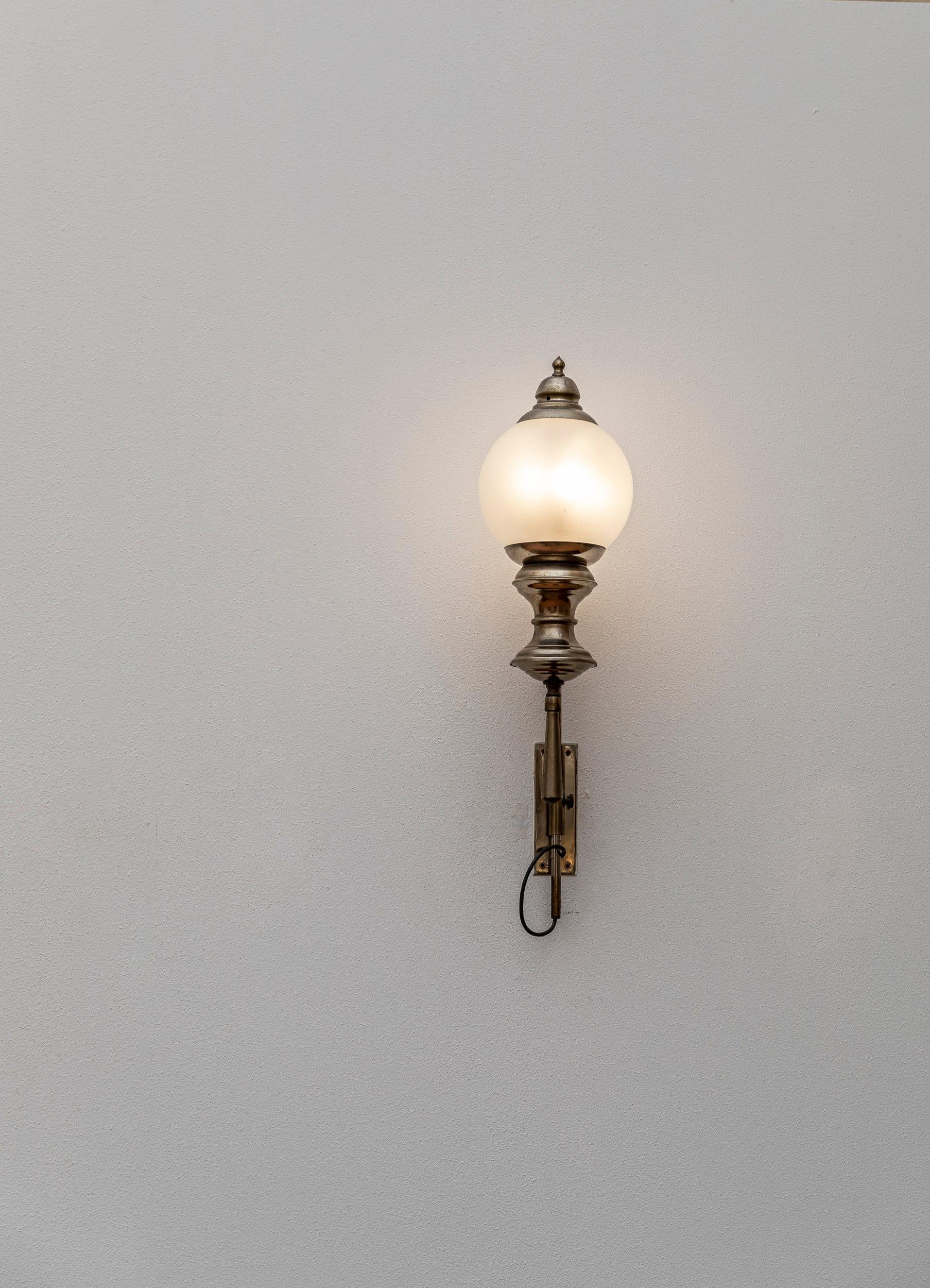 Classy and sophisticated set of three wall lights attributed to Luigi Caccia Dominioni. These lights have a sinuous arm and a decorated base holder made of brass. The lighting element is nestled in the brass structure and holds an elegant