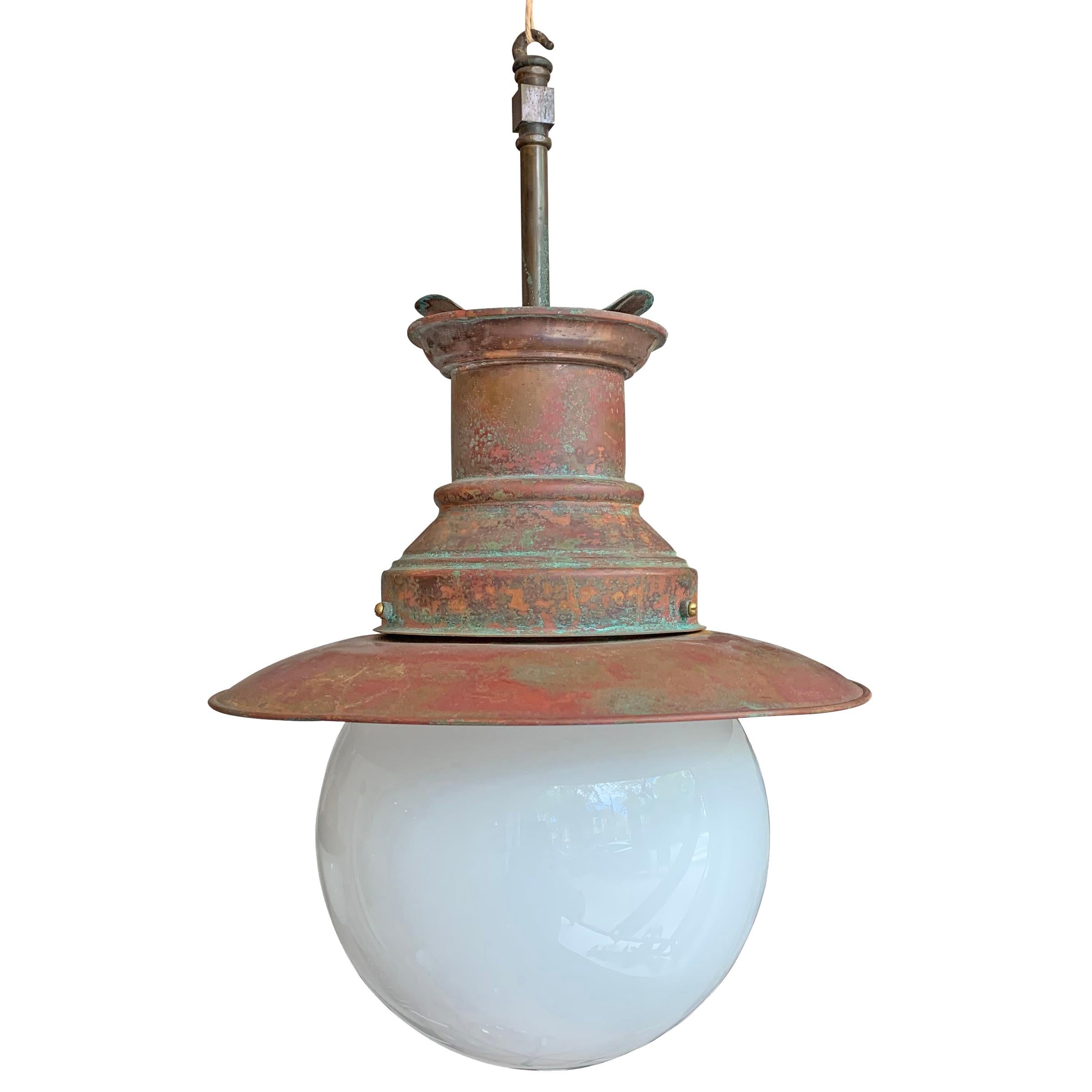 A fantastic set of three English copper pendant lights from a train station, with bronze rods for hanging. Not wired, but we can help with that if desired. Glass shades are newer replacements.