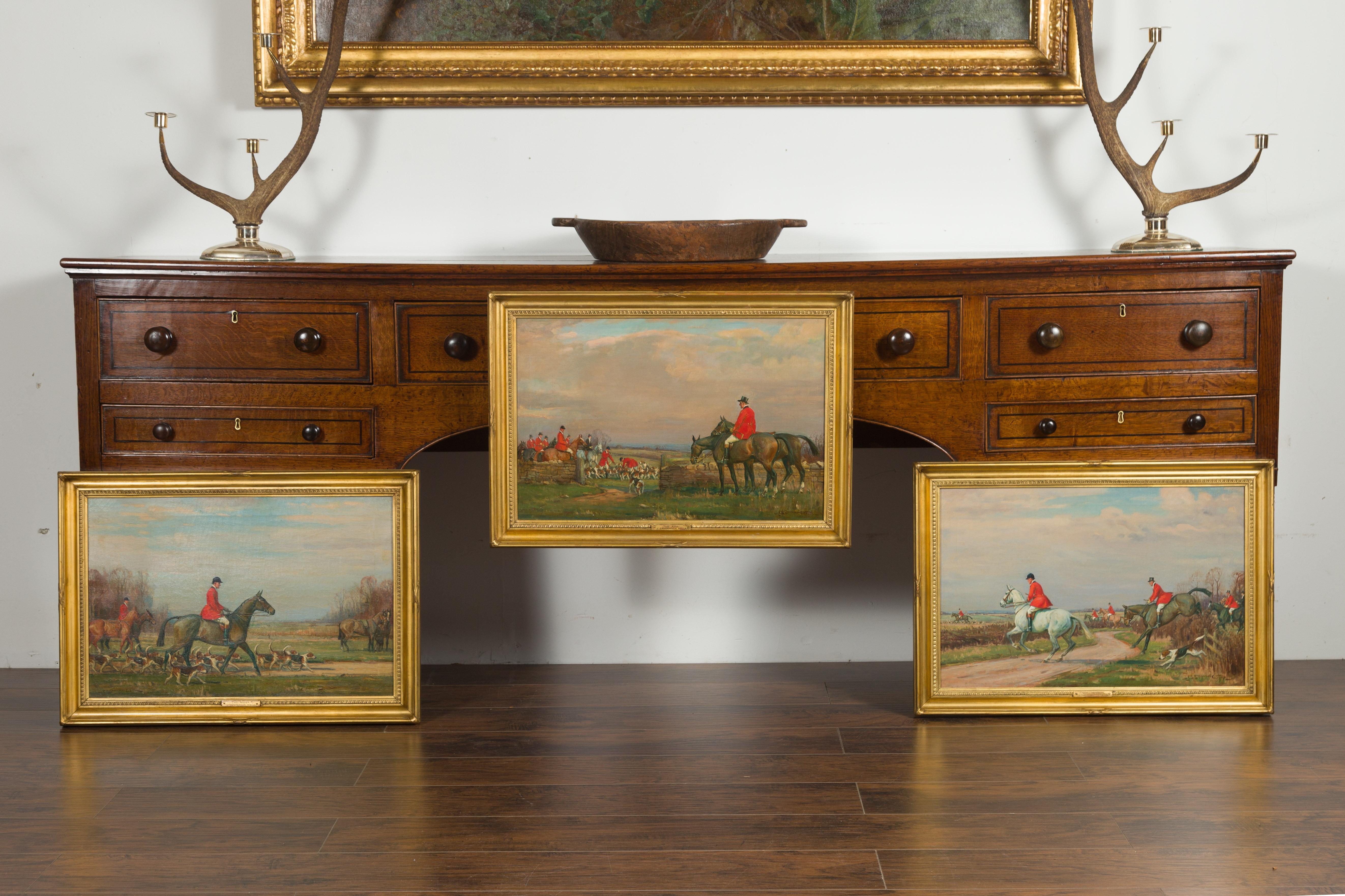 A set of three English gilt framed oil on canvas paintings depicting hunt scenes, signed John Sanderson Wells (1871-1955). Created in England during the first half of the 20th century, this set of three oil on canvas paintings depicts captivating