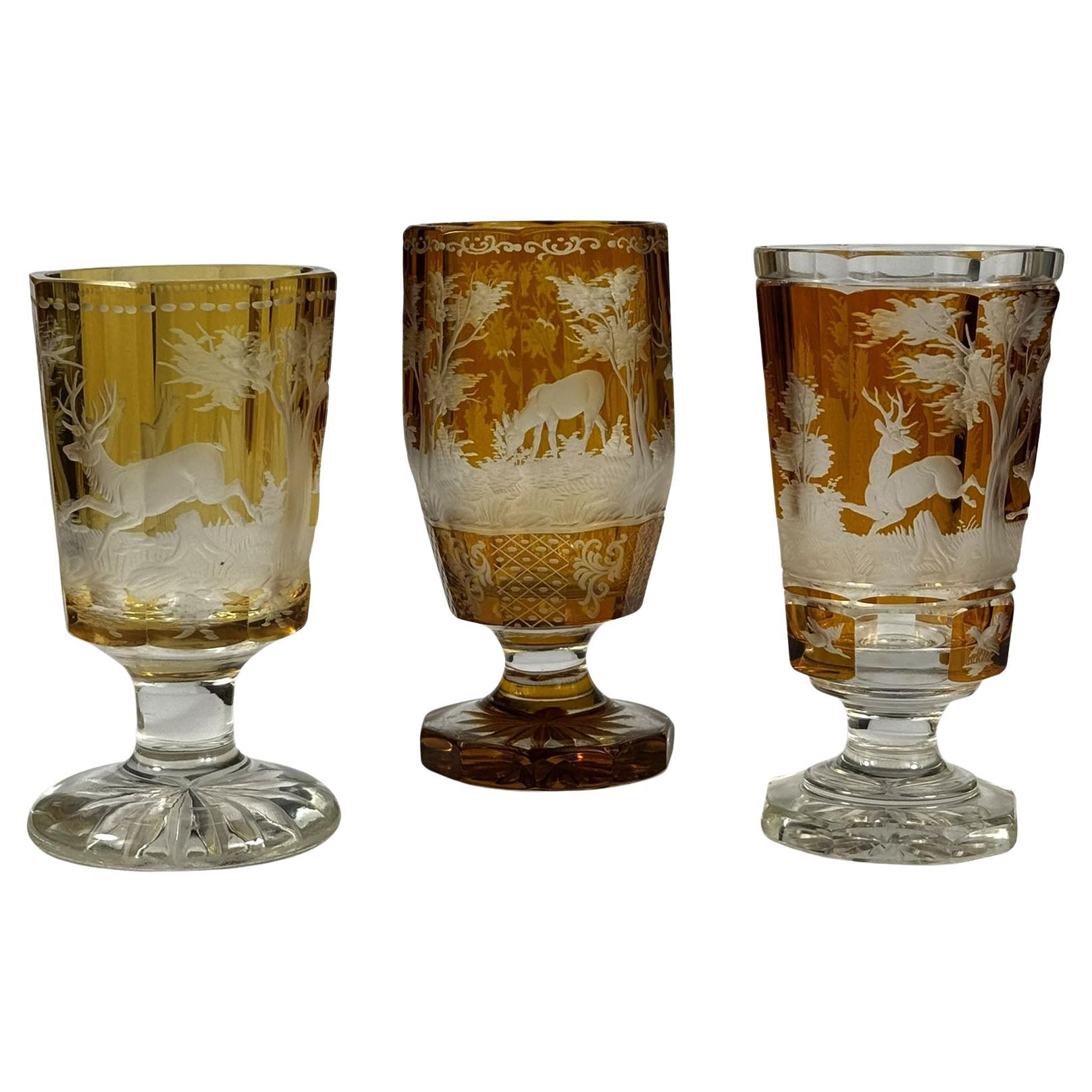Set di tre calici incisi, tagliati con smalto ambrato, XX secolo