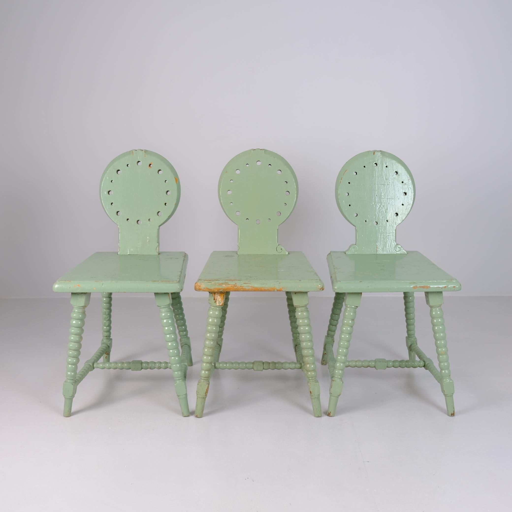 A characterful set of three folk chairs in the Tyrolean style, most likely of Finnish origin, dating from the early 1900s. The chairs are painted in a soft mint green, a later coat that has aged beautifully over time. Each chair features turned legs