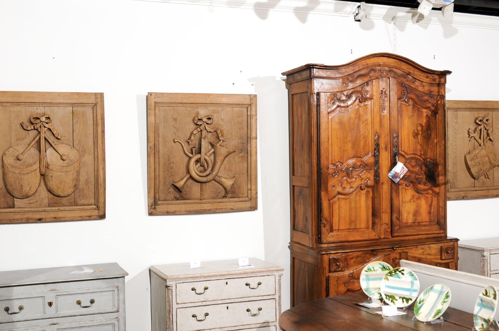 A set of three carved oak architectural panels from the 19th century, with ribbon-tied musical instruments. Created in France during the 19th century, each of these oak panels of nearly square shape, is adorned with a carved musical instrument