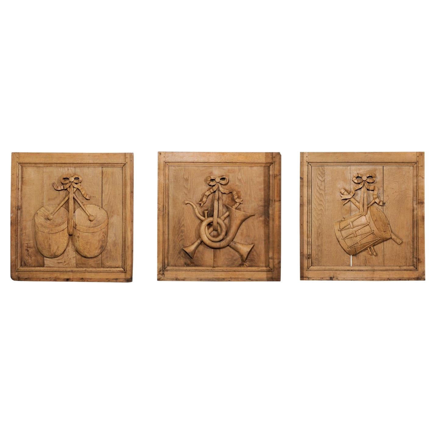 Set von drei französischen geschnitzten Eichenholztafeln aus dem 19. Jahrhundert mit Musikinstrumenten im Angebot
