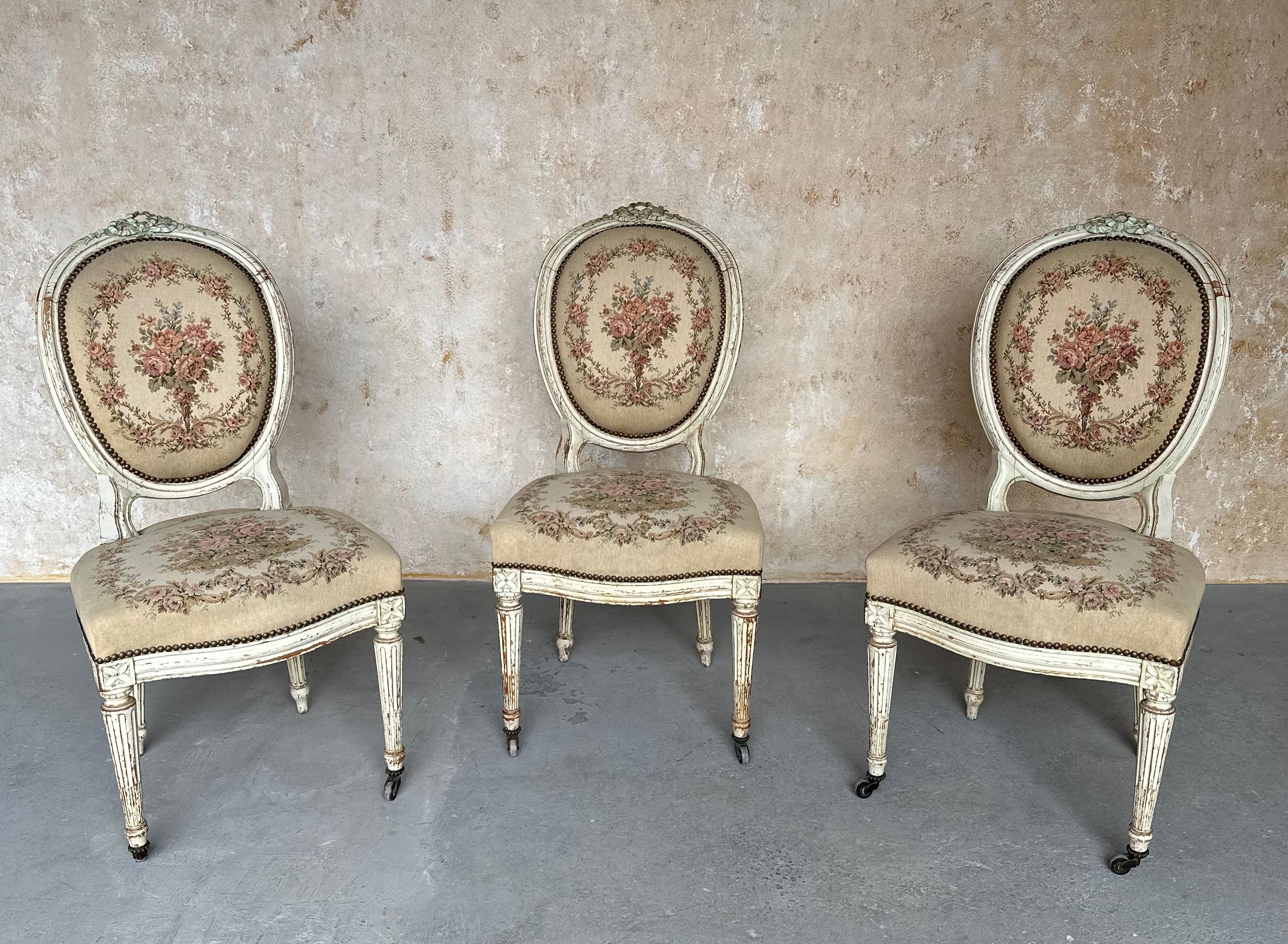 This beautiful set of three French 19th century Louis XVI style side chairs features petit point upholstery. The original patinated, finished frames have beautifully carved decorations and fluted legs and the fabric, a petit point floral design, is