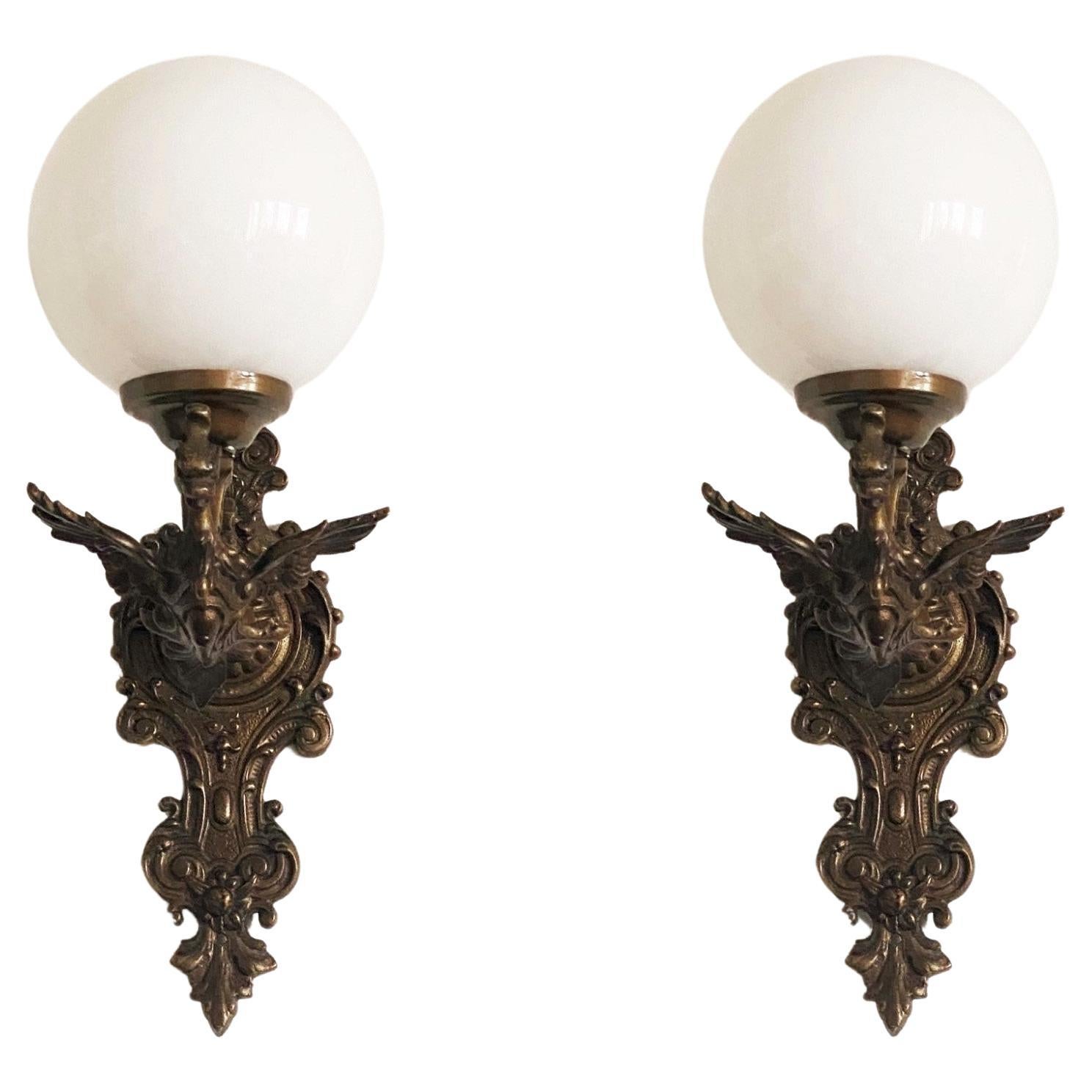Set of three bronze dragon wall lights with opaline glass ball globes, for indoor and outdoor use, France, 1930s
The wall sconces are in very good condition, beautiful patina, rewired.
Each sconce takes 0ne Edison E14 screw bulb. LED bulbs can also
