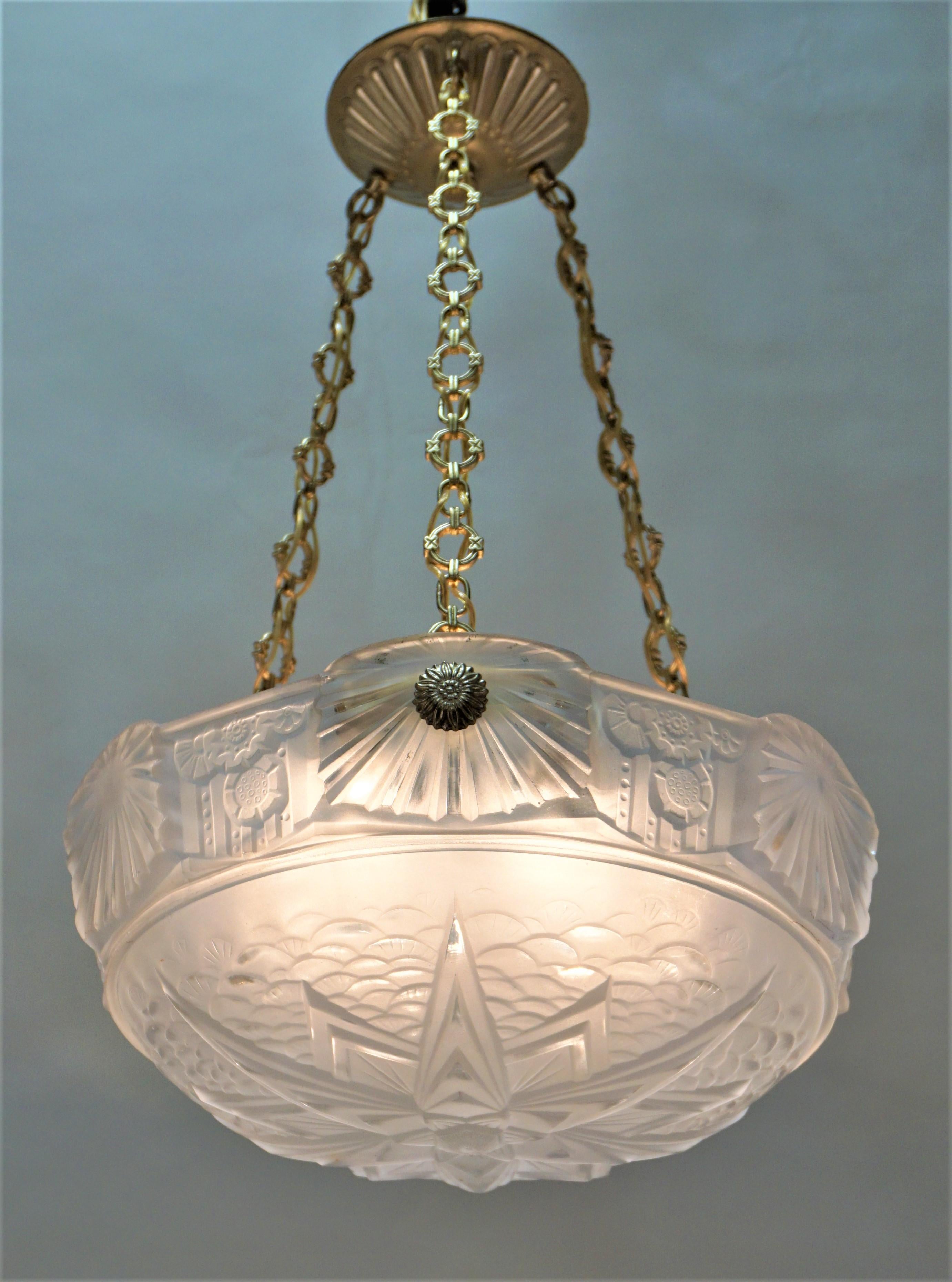 Set of three highly stylized with geometric pattern Art Deco pendant / chandeliers in clear frost by Muller Freres with bronze hardware.
Total of six lights 60 watt each.
Height can be adjusted by removing some of the chain.