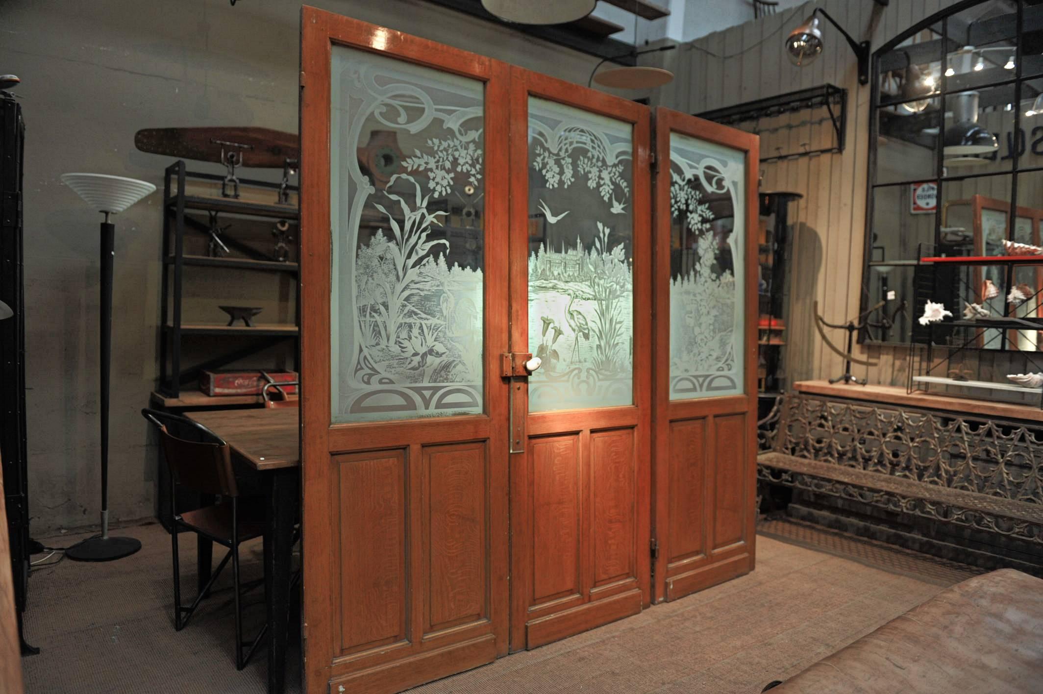 Set of three French interior vintage Art Nouveau pine wood doors, original faux bois painting and carved glass with herons, birds, and flowers Art Nouveau decor, all in excellent condition. Each door is 75 cm large (29.72 inches) weight 20 kg each.