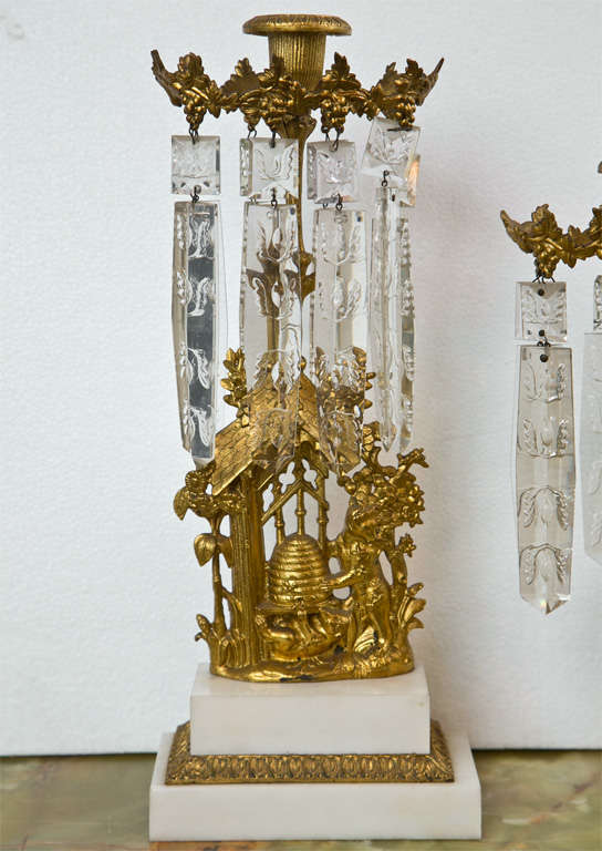 Set of three French Belle Époque style gilt-metal candelabras, the center piece has three arms, the other two each has one arm, all decorated with etched prisms, raised on white marble bases. The measurement below is for the center piece only, the