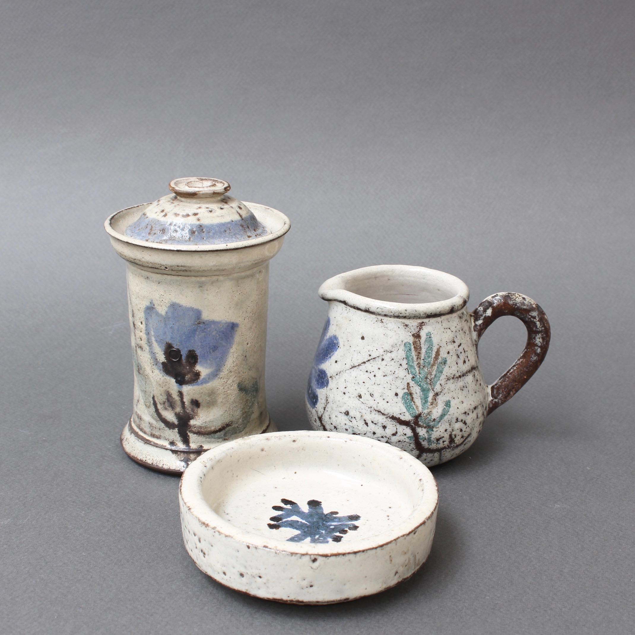 Set of three small, French ceramic pieces by Gustave Reynaud for Le Mûrier (circa 1950s). A very charming set includes a small apothecary jar, milk creamer and receptacle dish. All incorporate Reynaud's signature style, chalk-white color base with