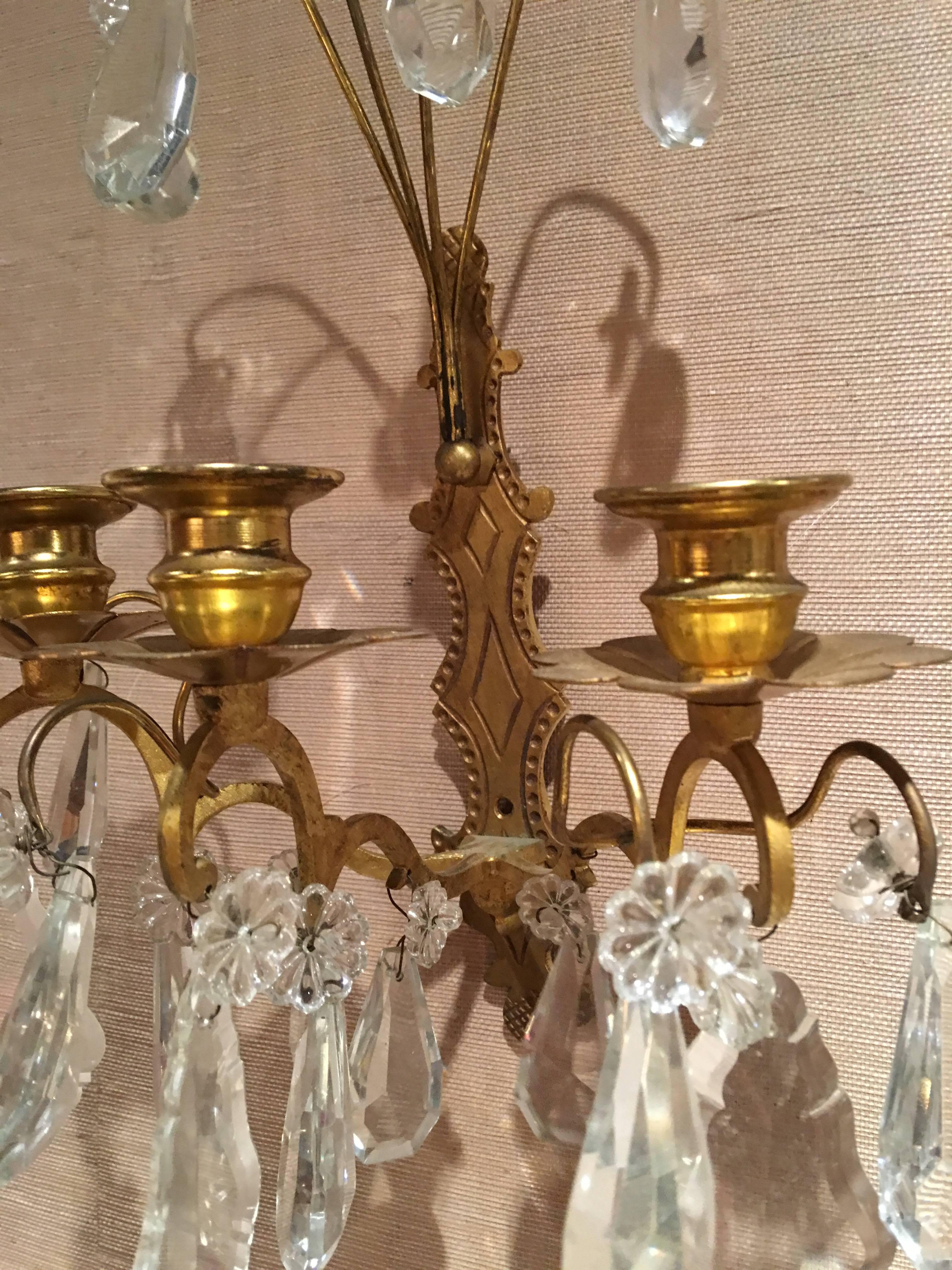 Set of three French gilt metal and crystal sconces, 19th century.