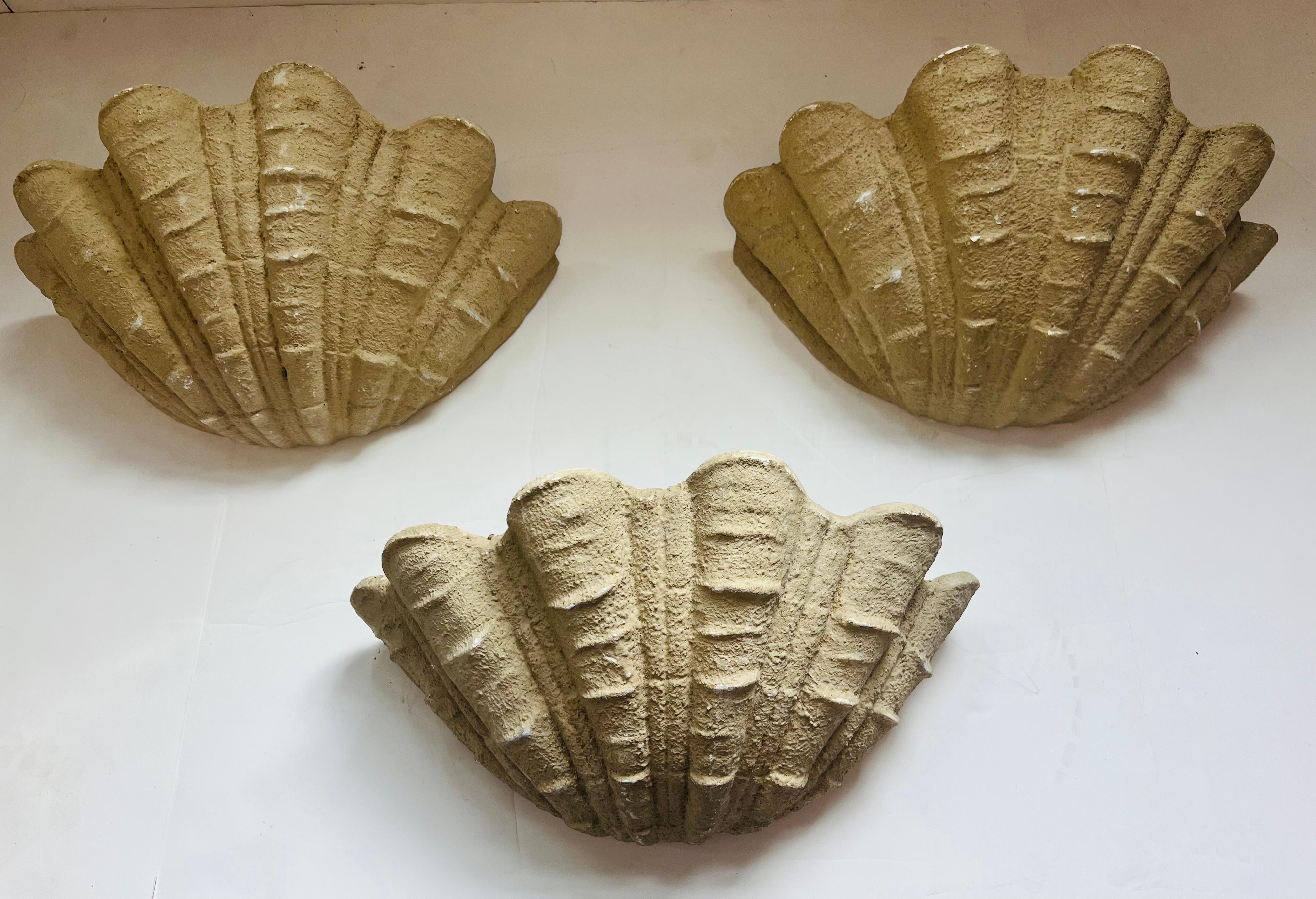 Set of three French Art Deco beige plaster wall lights by Serge Roche styled in oyster shell design. Rewired with standard sockets.