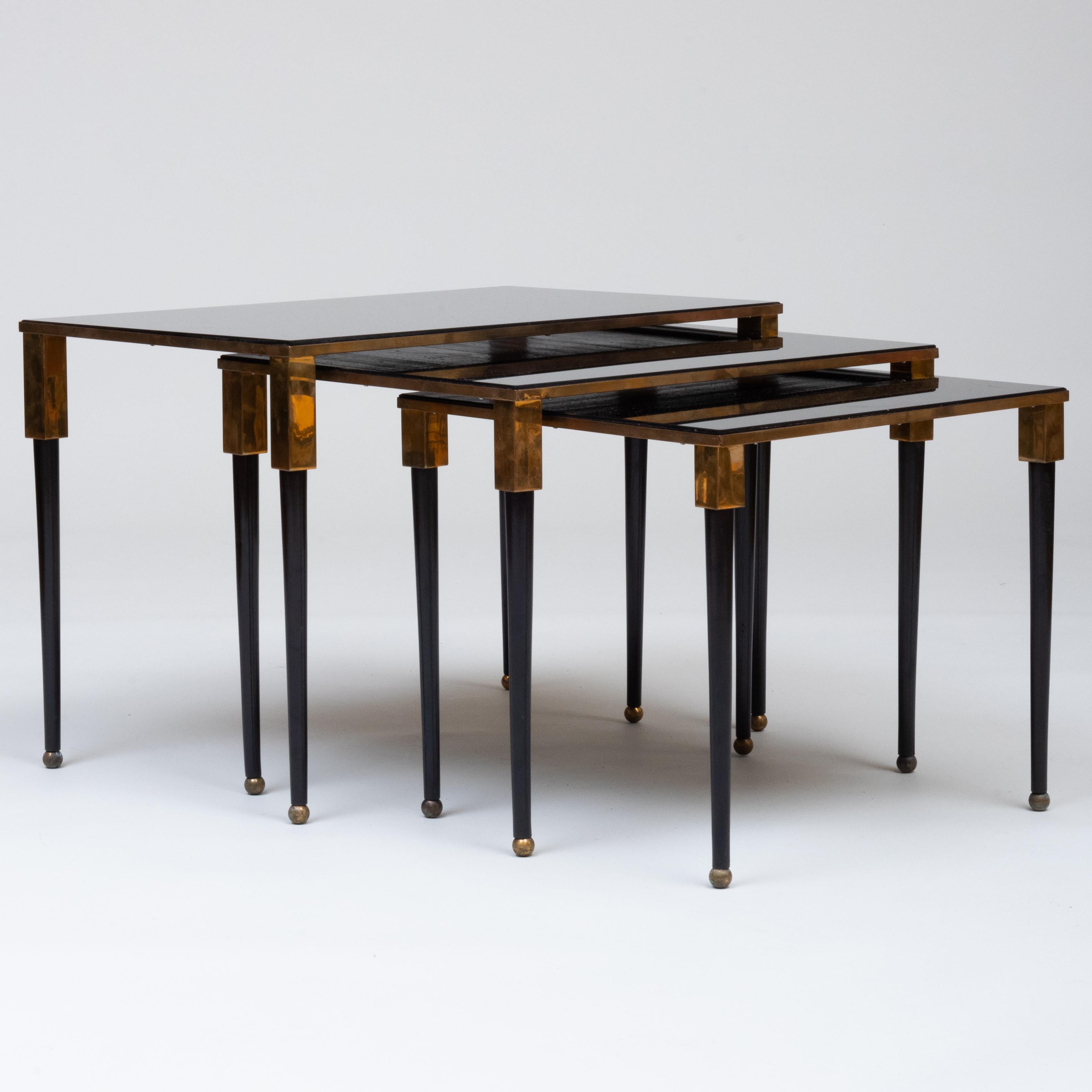 Set of 3 brass nesting tables by French Art Moderne inset with black glass top. Provenance: Bernd Goeckler Antiques, Inc., NY., February 9, 2007.