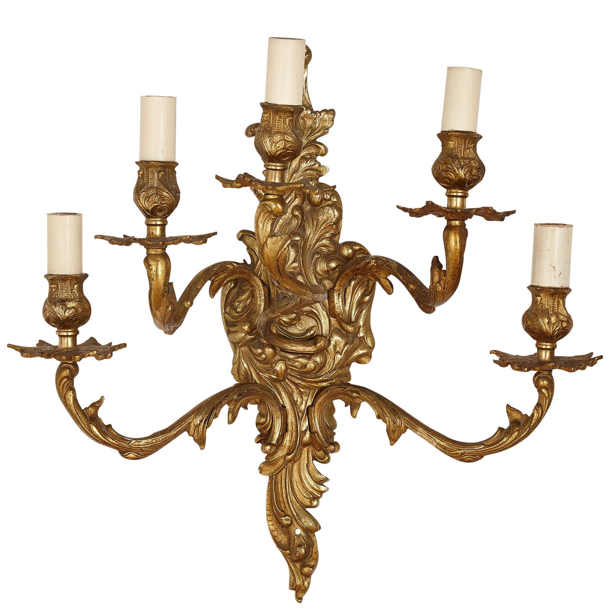 Set of three gilt bronze sconces in the Baroque style
French, early 20th century
Measures: Height 48cm, width 49cm, depth 26cm

The sconces in this set are wrought from gilt bronze in the Baroque style. Each sconce features an acanthus leaf
