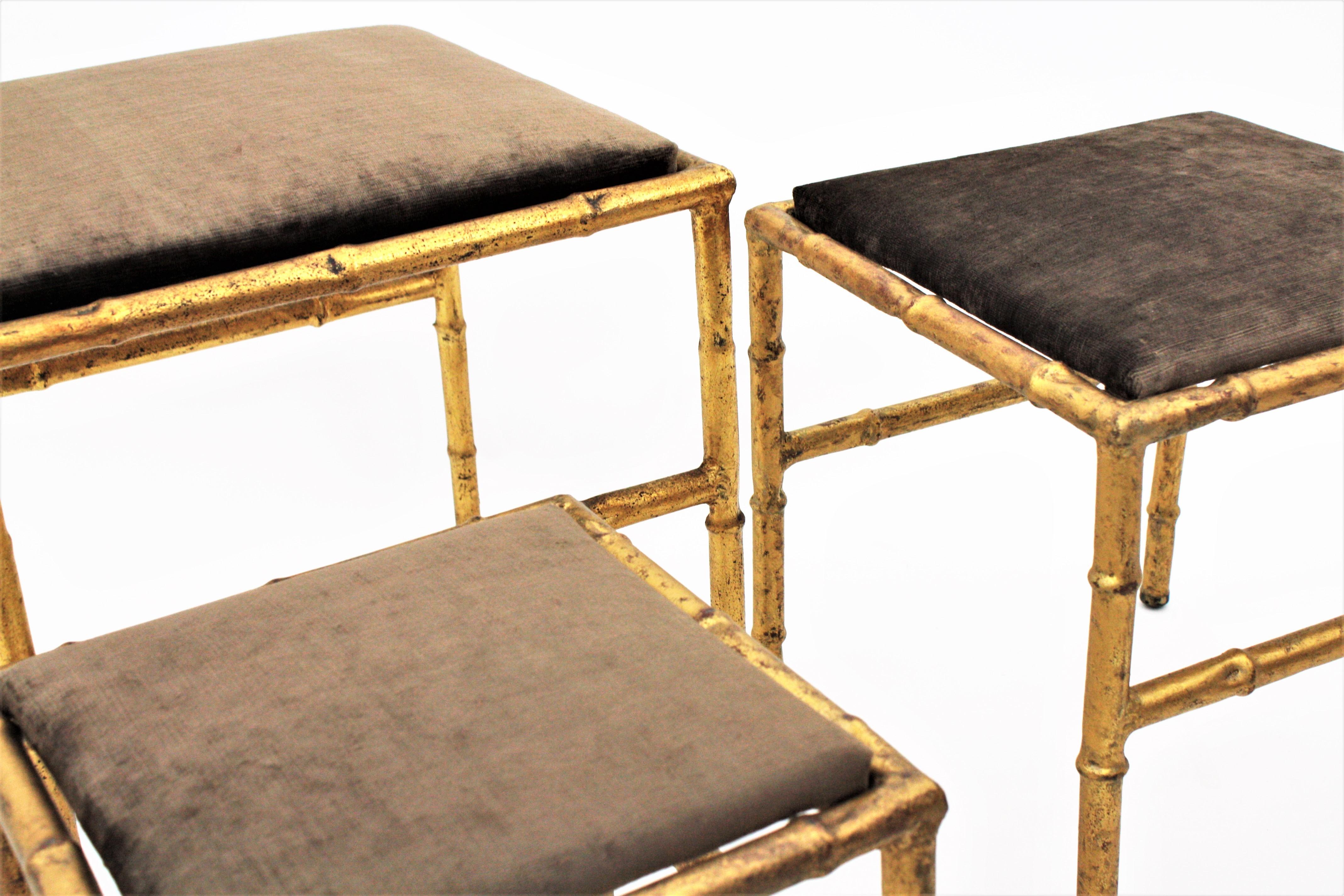 Elegant nest of gold leaf gilt iron faux bamboo stools with velvet upholstery, France, 1940s.
This beautiful set of footstools have been totally refurbished in a taupe / brown / grey velvet fabric. They could also work as nesting tables changing