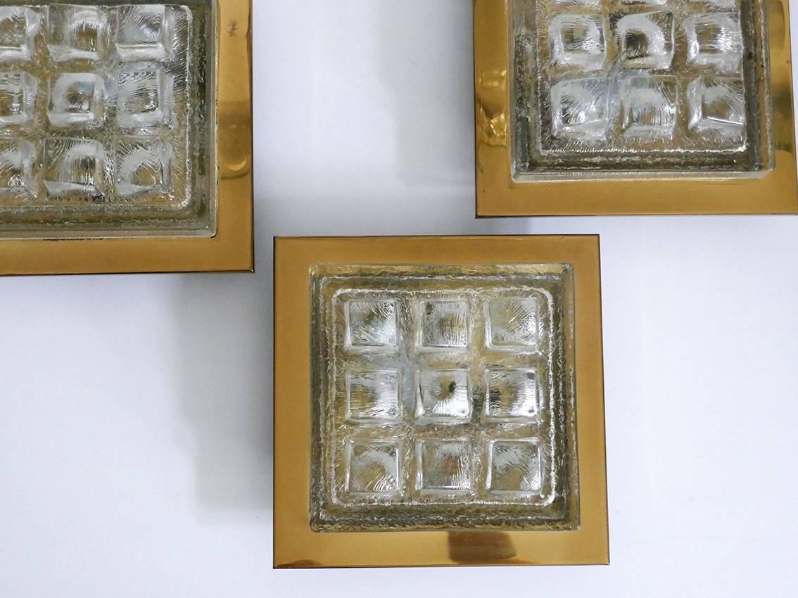 Beautiful and rare set of three vintage geometric ice block glass and brass wall or ceiling flush mounts.
Germany, 1960s.
Lamp socket: One.
One light has a chip, which only affects the border of the glass and is completely hidden by brass