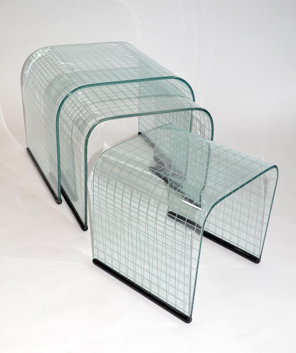 Set of three glass side nesting or stacking tables, Fiam, Italy, 1980s. Graduated side or nesting-sized with decorative reverse etched grid on plate glass with black painted wood bases. Simple, Minimalist waterfall design. Very good vintage