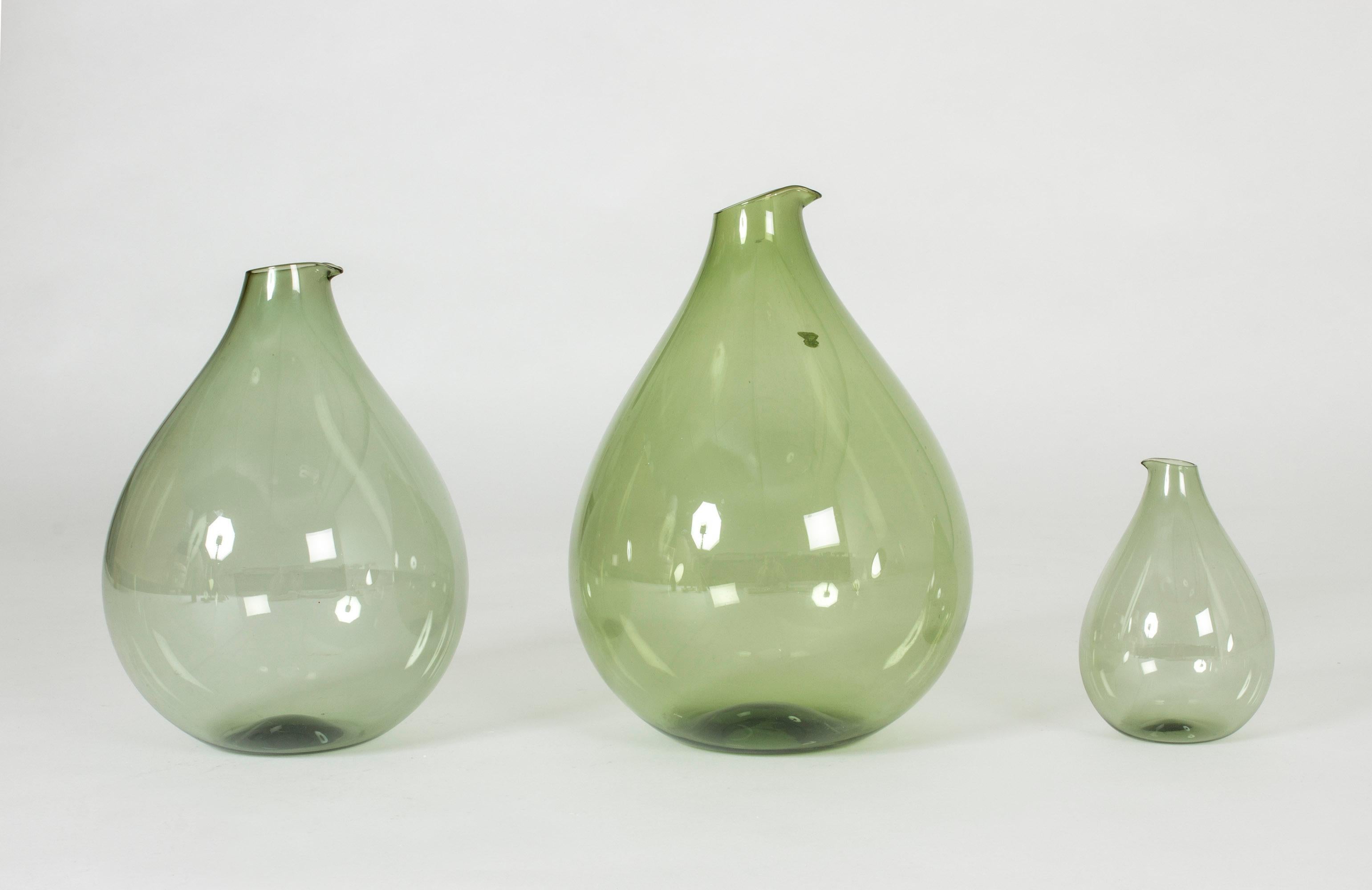 Set of three beautiful vases or decanters by Kjell Blomberg. Made in thin, green glass with a look of soap bubble delicacy, in generous drop shapes.

The dimensions of each vase are as follows:
Heights 36, 32, 18 cm
Diameters 27, 23, 13 cm.