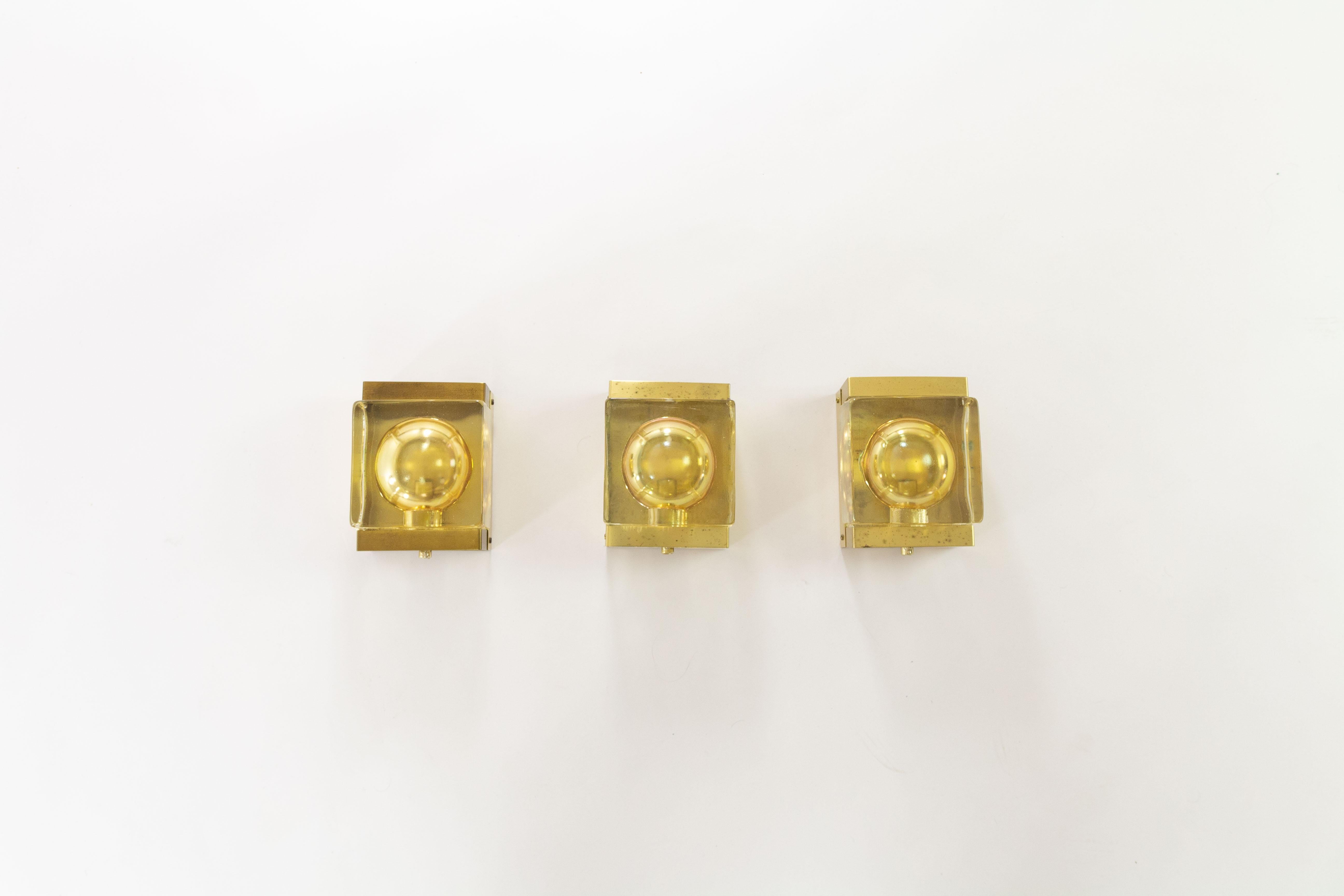 Set of three gold coloured handmade Maritim Lampet wall lamps, produced by Danish lighting manufacturer Vitrika in the 1970s.

Each lamp consists of two parts: a solid and so rather heavy handmade glass body (2.4 kg / 5.3 lbs) and the brass