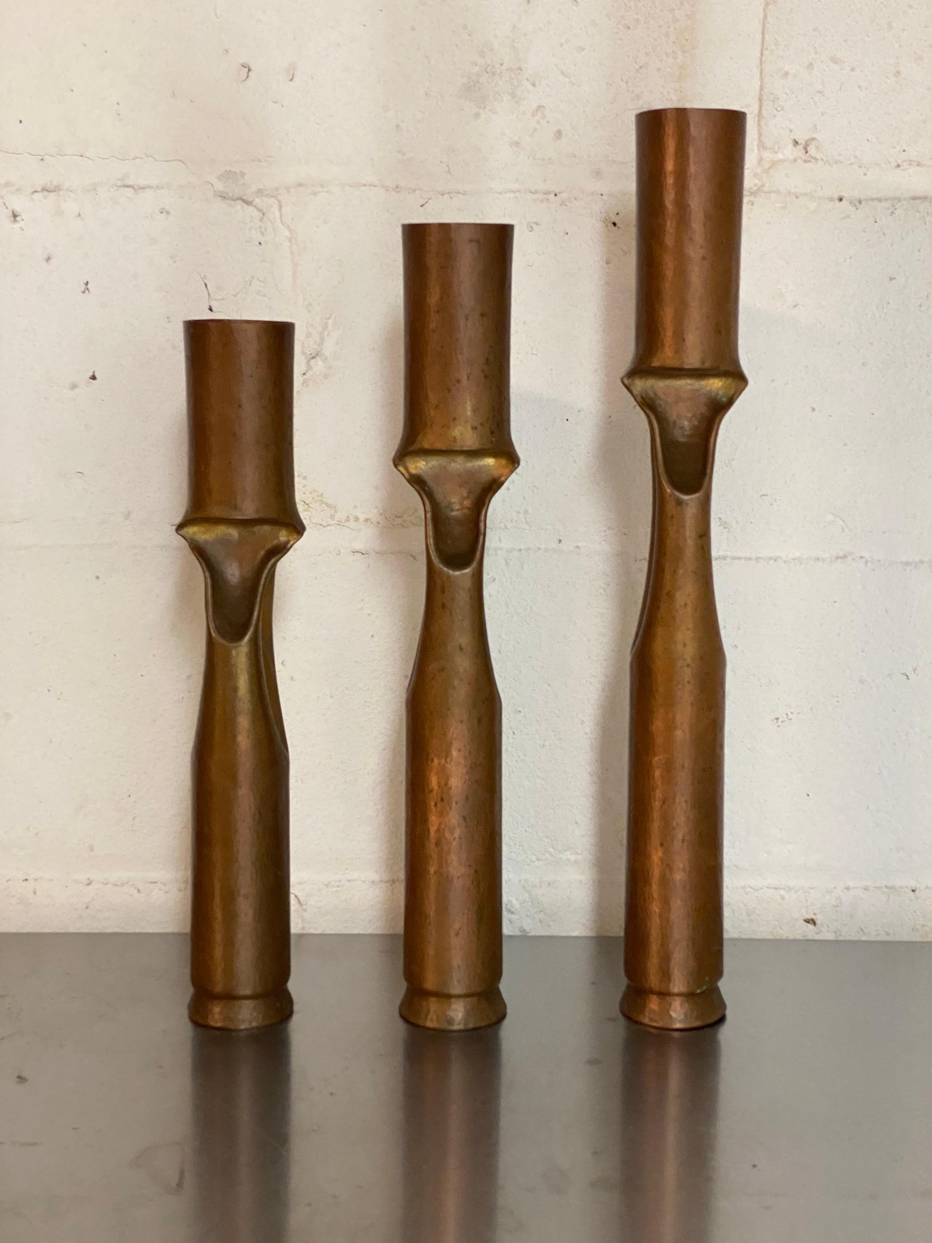 A set of three graduated Brutalist Period copper candleholders by Thomas Roy Markusen. Circa 1968-1972. Markusen was a trained, silversmith, blacksmith and metalsmith, adept at forging and manipulating all types of metals and alloys from silver,