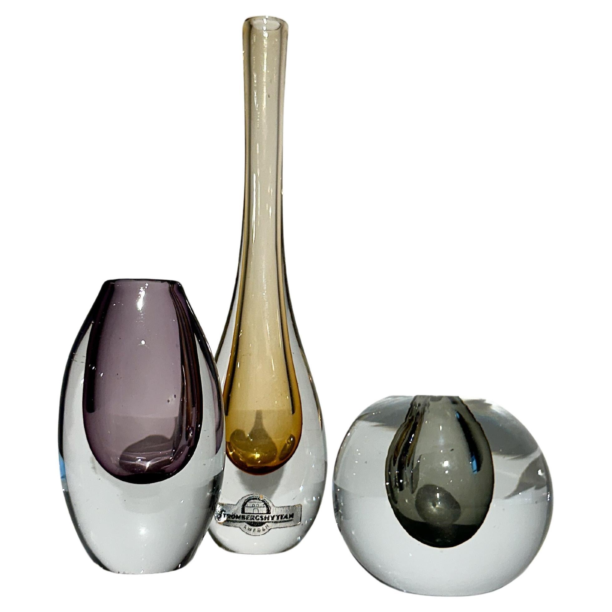 Set of three of miniature vases by Asta Strömberg & Gunnar Nylund for Strömbergshyttan glass factory in the late 1950s to early 1960s.

Height: 4 cm, 6.5 cm, 13 cm
Width: 3.5 cm, 4 cm

All vases are signed underneath, the tall vase remains the