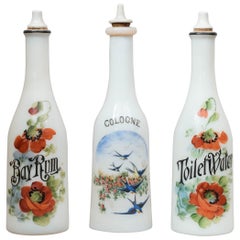 Ensemble de trois bouteilles en verre de lait peintes à la main pour salon de coiffure:: vers 1900