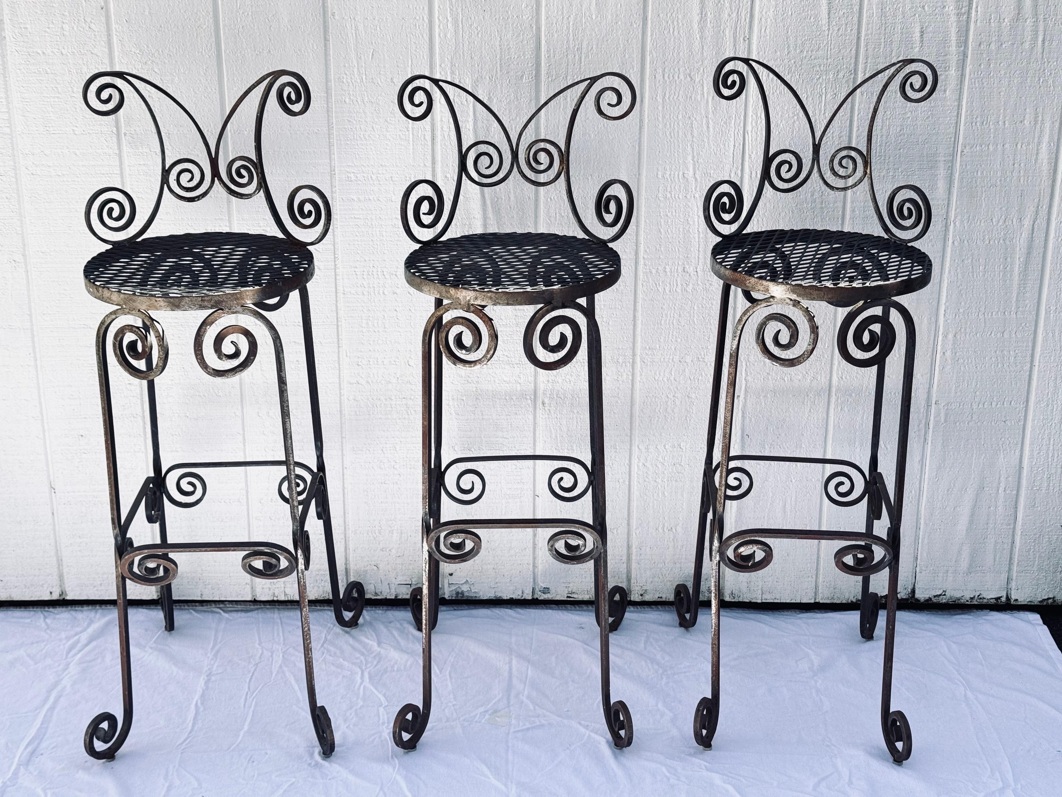 Ensemble de trois tabourets de bar en fer forgé à la main. Magnifique artisanat forgé à la main. Il s'agit de tabourets de bar extra hauts pour un extérieur plus élevé. La hauteur du plateau de bar est généralement conçue pour des tables plus hautes