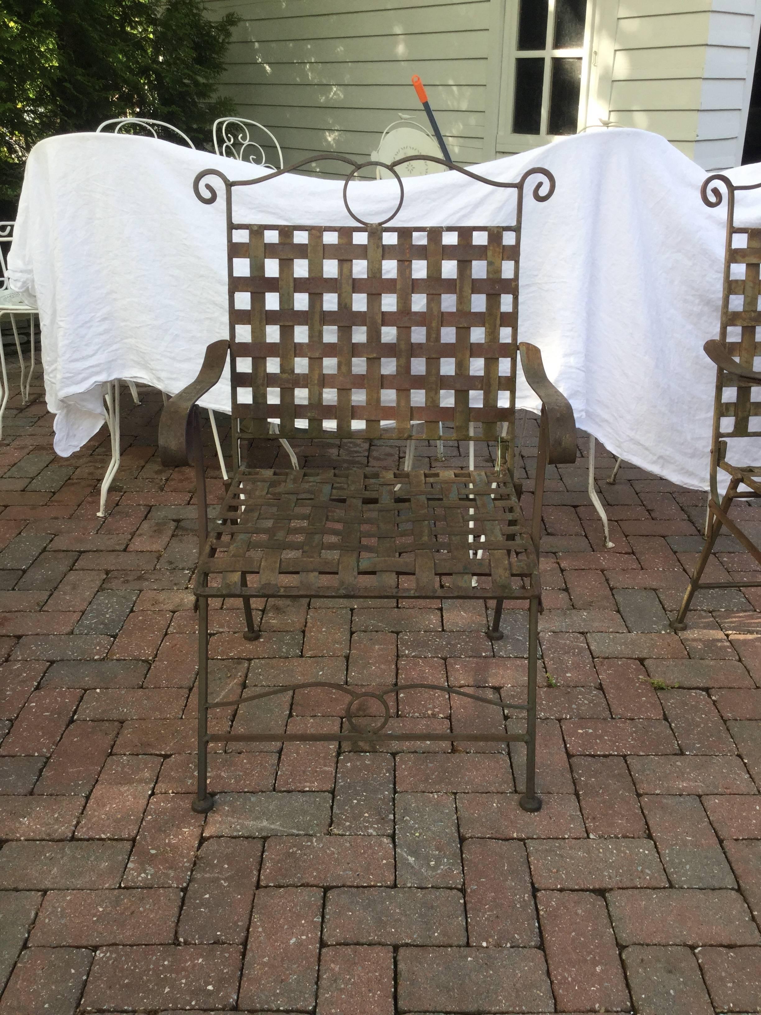 Three heavy iron and nicely weathered outdoor armchairs having woven strips of iron with a generous-size seat and back. Natural patina to the brown iron. Seat height 18,
circa 1970s.
   