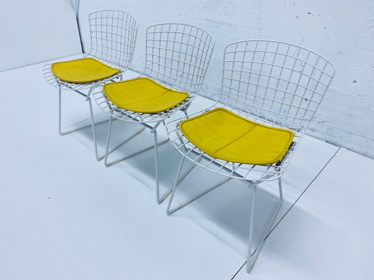 Original 1950s set of three Harry Bertoia wire child's side chairs with yellow Naugahyde seat cushions for Knoll. Each chair maintains the original Knoll label on the underside.