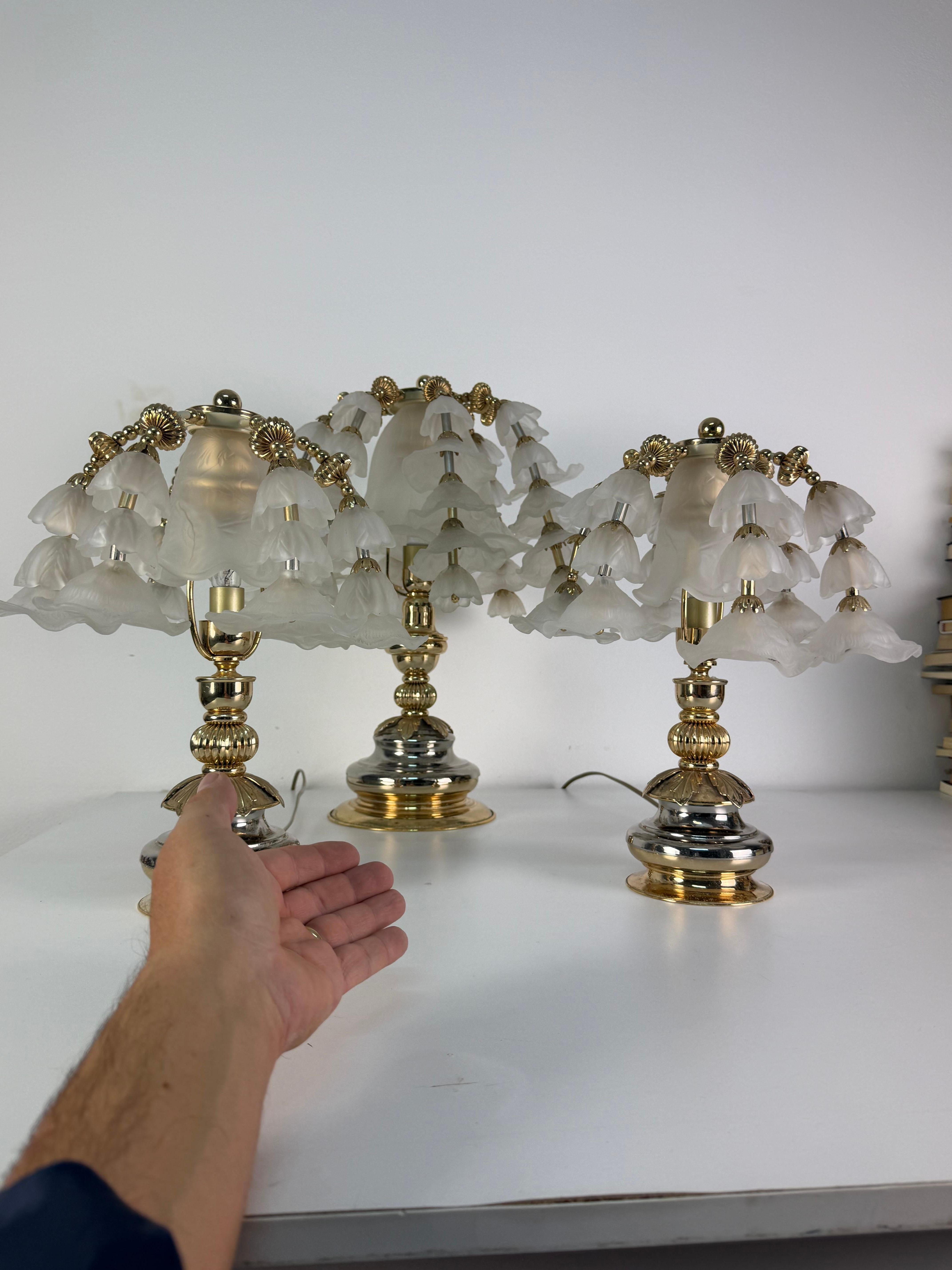 Set of three Hollywood Regency bedroom table lamps, attributed to Banci, 1980s
Chrome-plated and gold-plated metal frame, lampshades with opaline glass flowers.
The glass is intact, with small signs of aging on the frames.
The largest, designed for