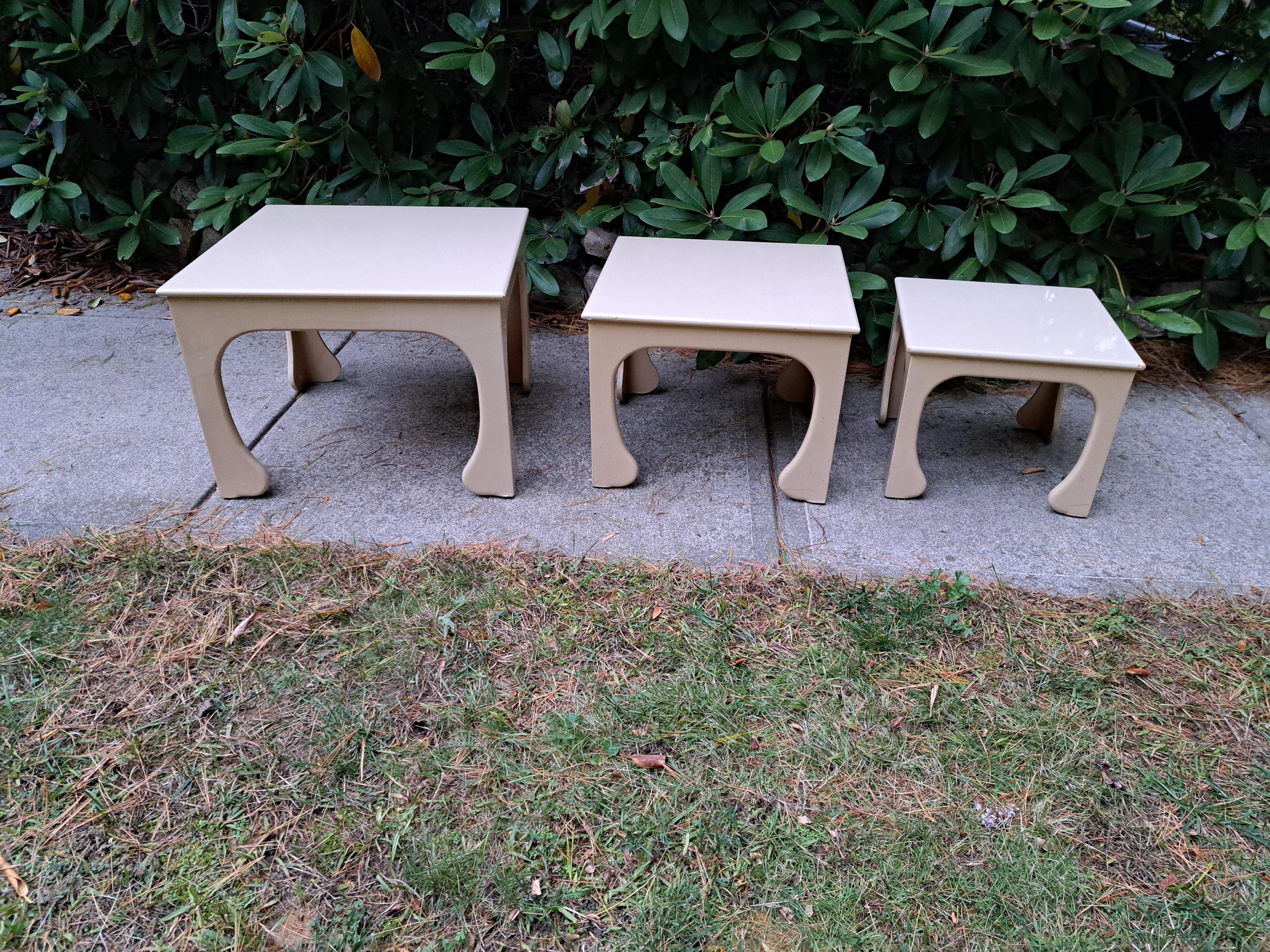 Set di tre tavolini Hollywood Regency con base a gambe curve e rivestimento in lacca. I tavoli in stile italiano sono in buone e robuste condizioni. Il colore guscio d'uovo si abbina a qualsiasi arredamento.