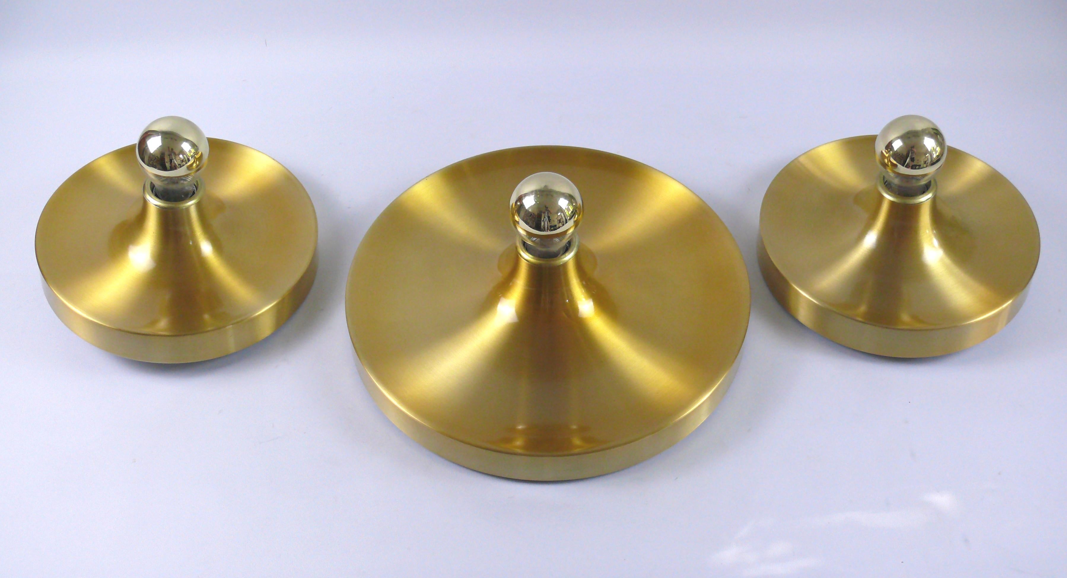 Set of 3 x original disc lights by Honsel, Germany, 1960s. 2 pieces diameter 25 cm, 1 piece diameter 35 cm.
The lights are made of brushed aluminum and coated in gold. The lights can be attached to both the ceiling and the wall. They have an E 27