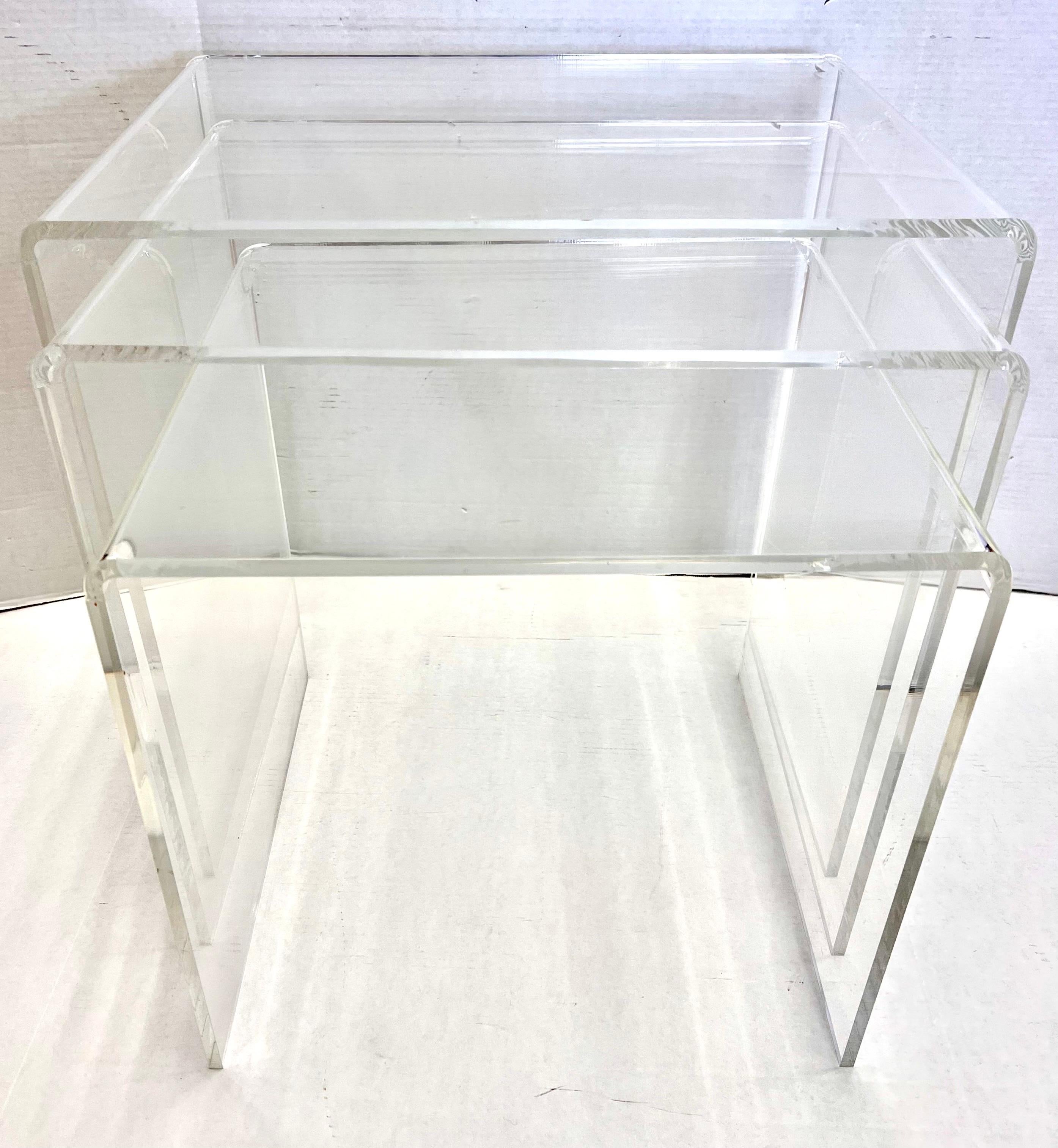 Vintage midcentury Lucite nesting waterfall tables made of molded arylic with clean edges. They nest together perfectly or can be scattered, your call! These are true period pieces, not the cheap lightweight plastic reproductions in other homes -